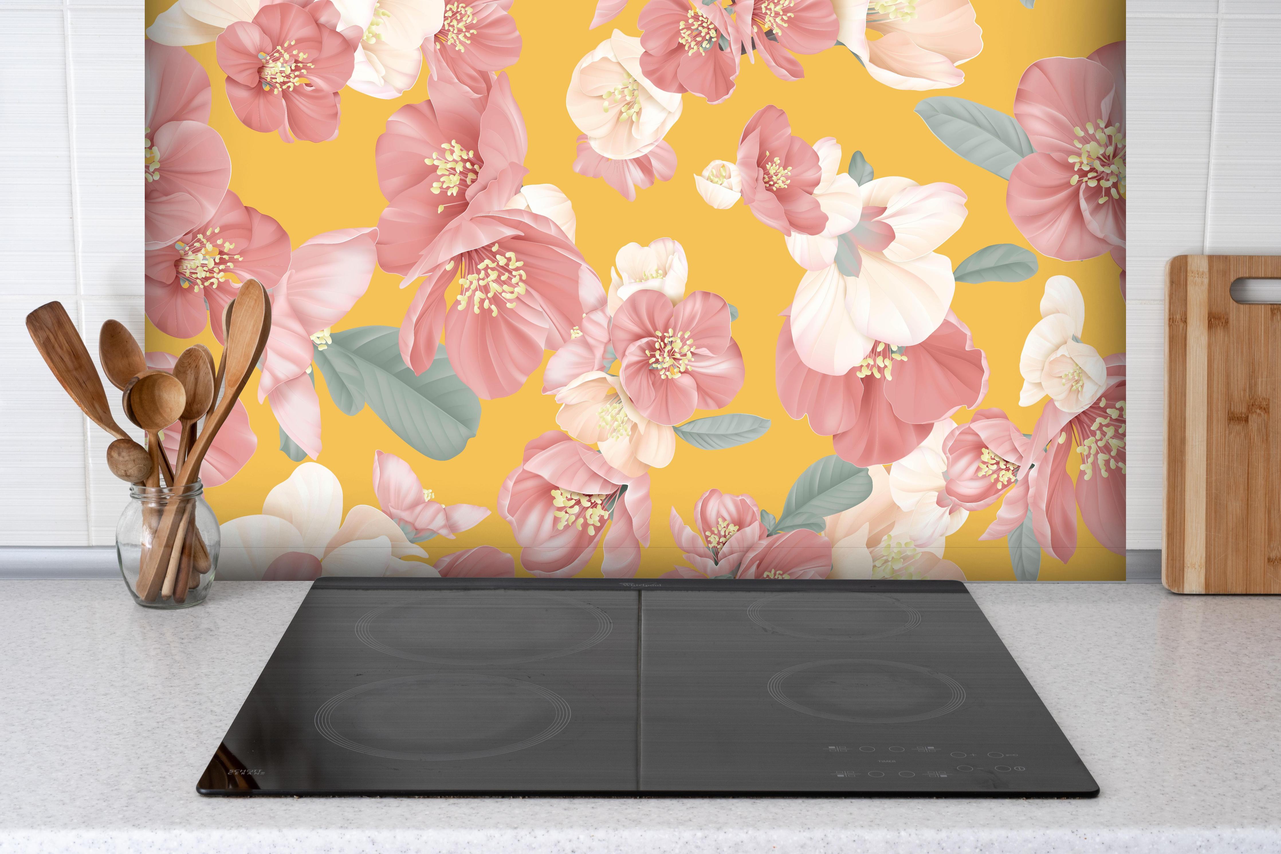Spritzschutz - Vintage Quince Blumenmuster Pastellgelb hinter einem Cerankochfeld zwischen Holz-Kochutensilien
