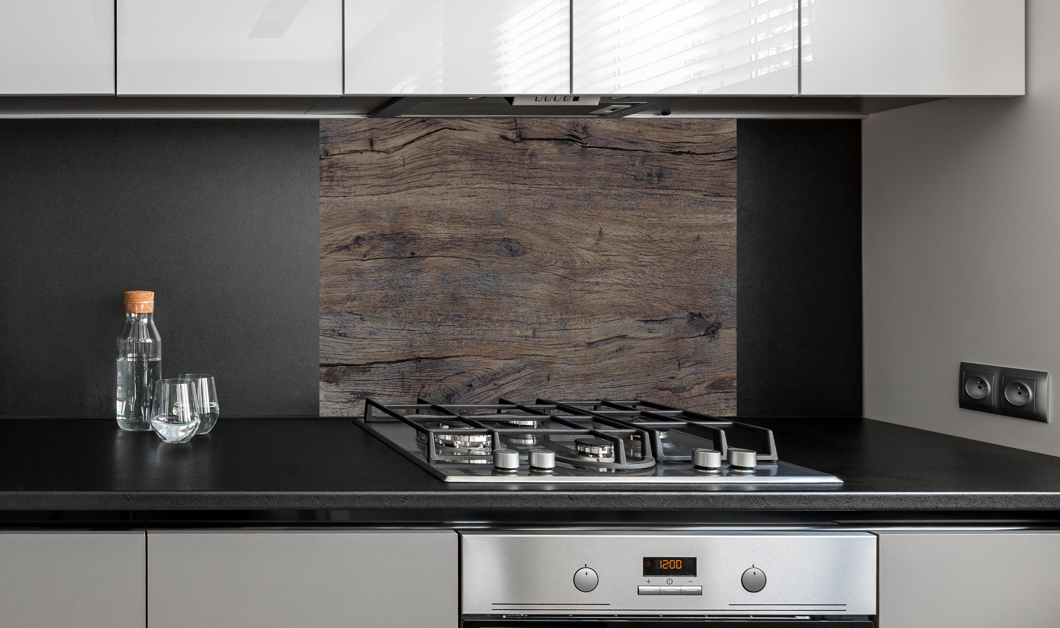 Spritzschutz - Vintage gräuliche Holztextur hinter einem Cerankochfeld zwischen Holz-Kochutensilien
