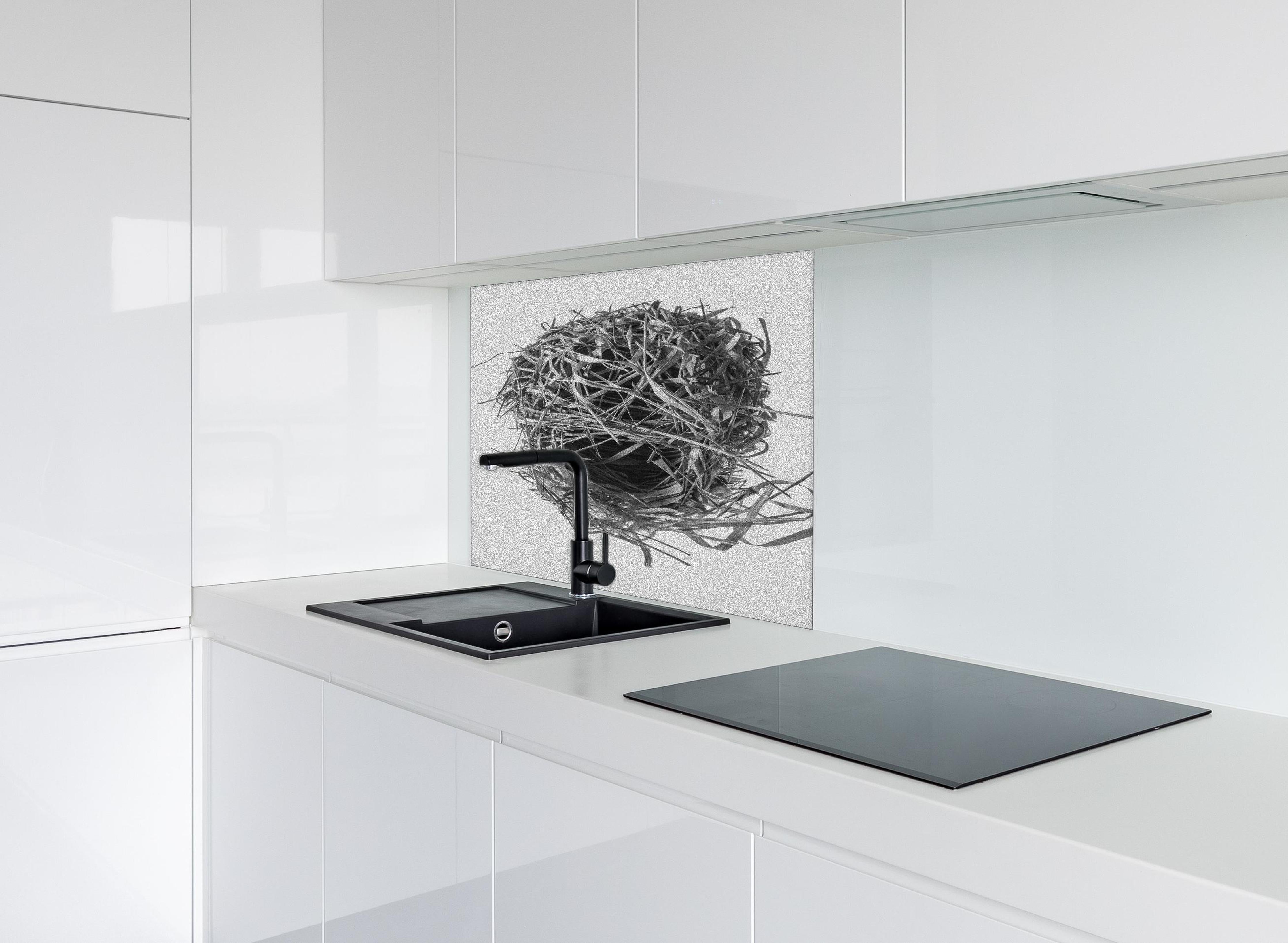 Spritzschutz - Vogelnest - schwarz-weiß hinter einem Cerankochfeld zwischen Holz-Kochutensilien
