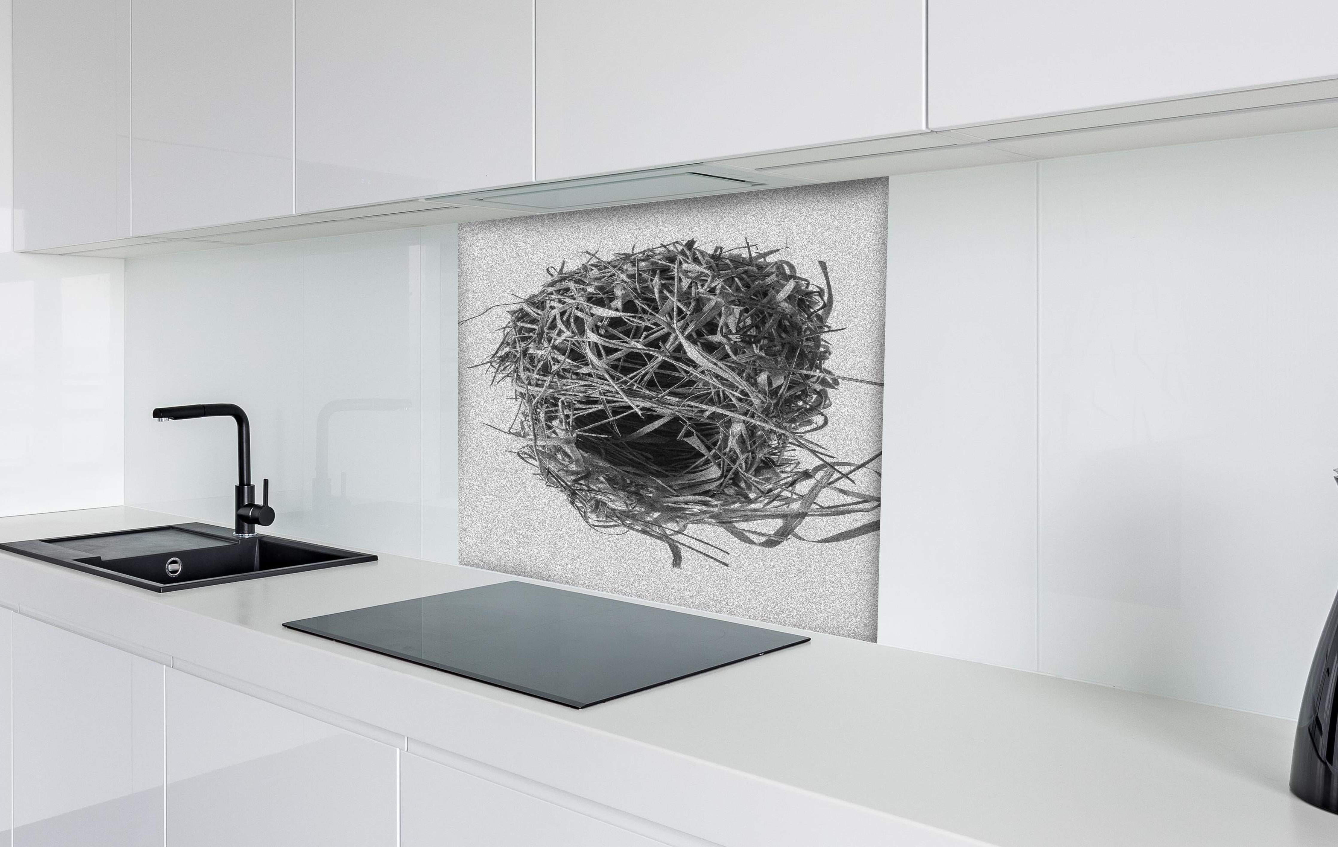 Spritzschutz - Vogelnest - schwarz-weiß hinter einem Cerankochfeld zwischen Holz-Kochutensilien
