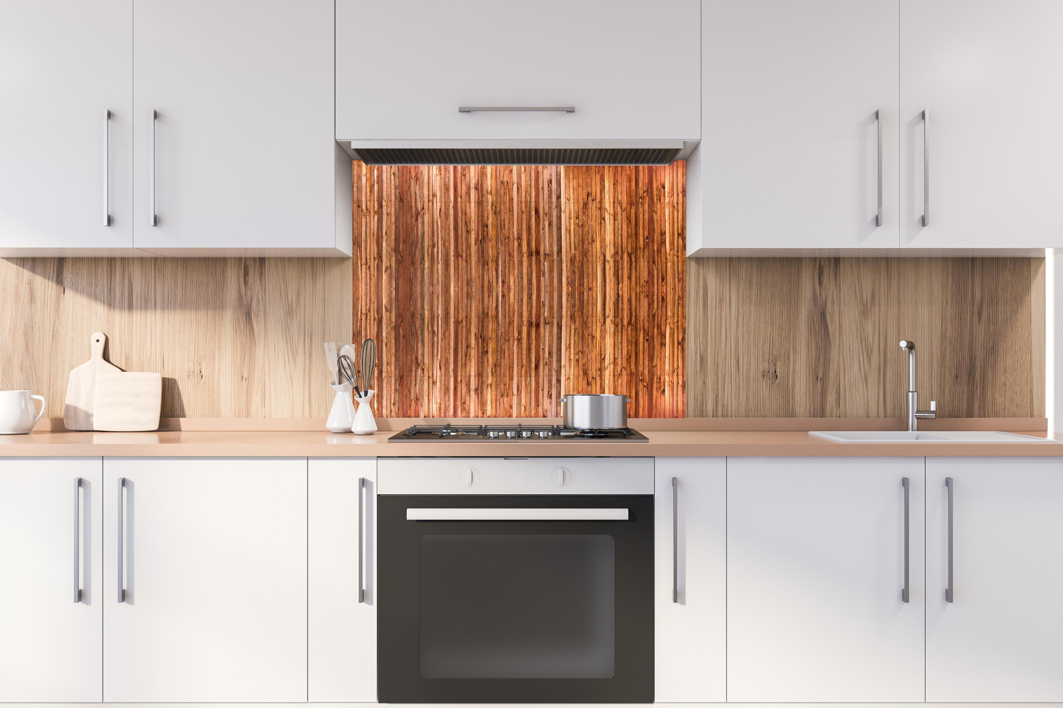 Spritzschutz - Warme Rustikale Holzstruktur Braunton hinter einem Cerankochfeld zwischen Holz-Kochutensilien
