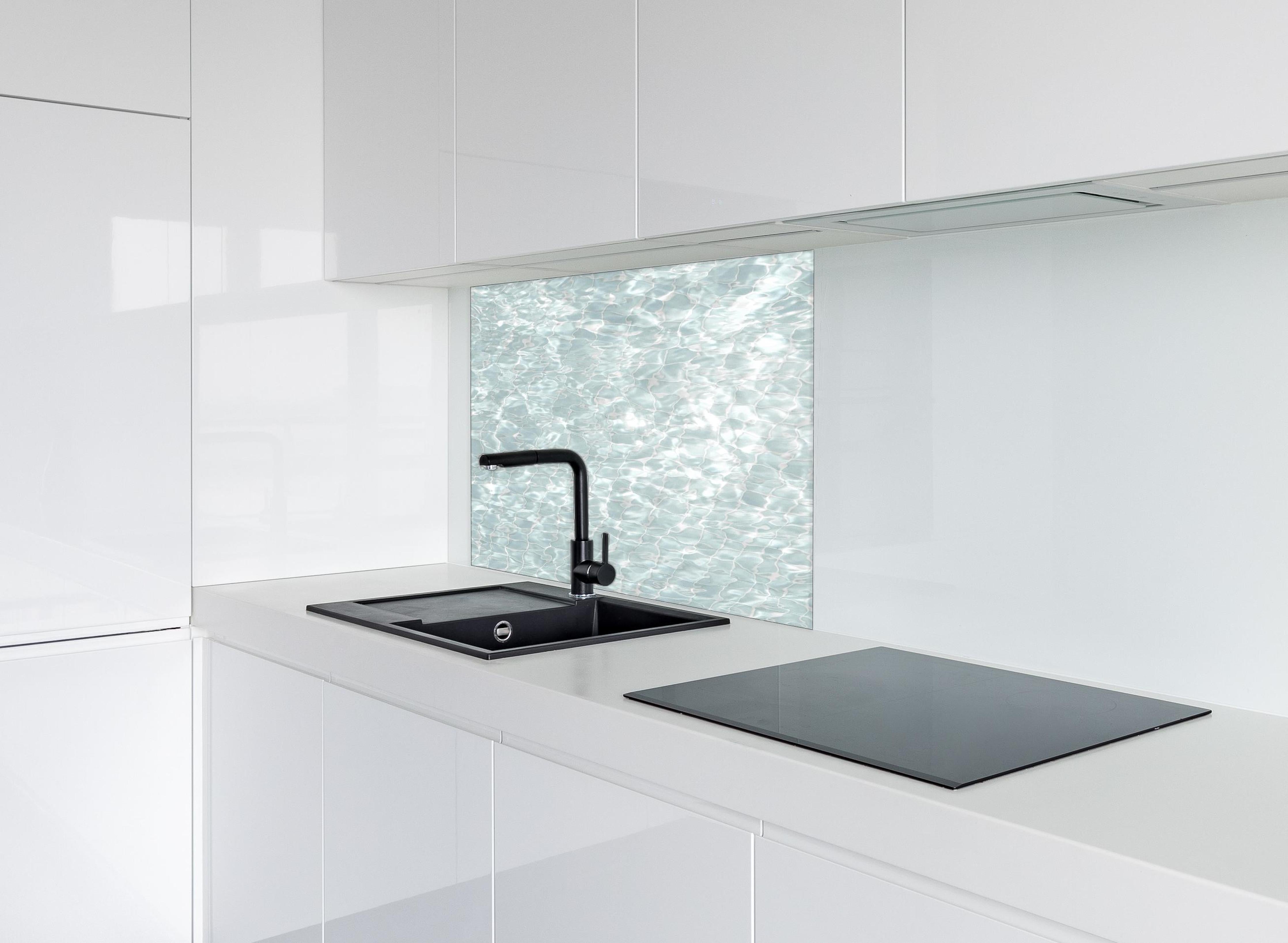 Spritzschutz - Wasseroberfläche hinter einem Cerankochfeld zwischen Holz-Kochutensilien
