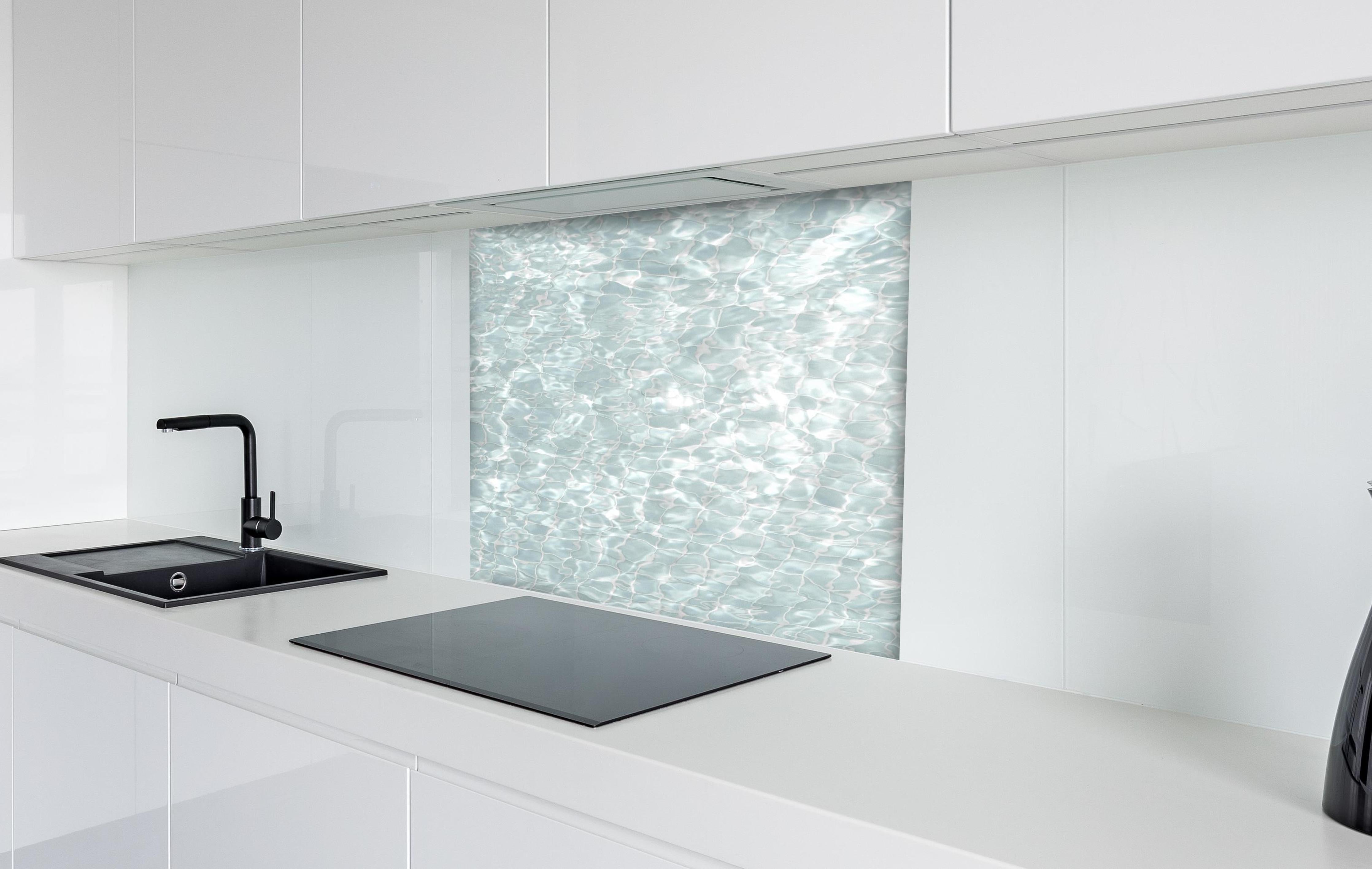 Spritzschutz - Wasseroberfläche hinter einem Cerankochfeld zwischen Holz-Kochutensilien
