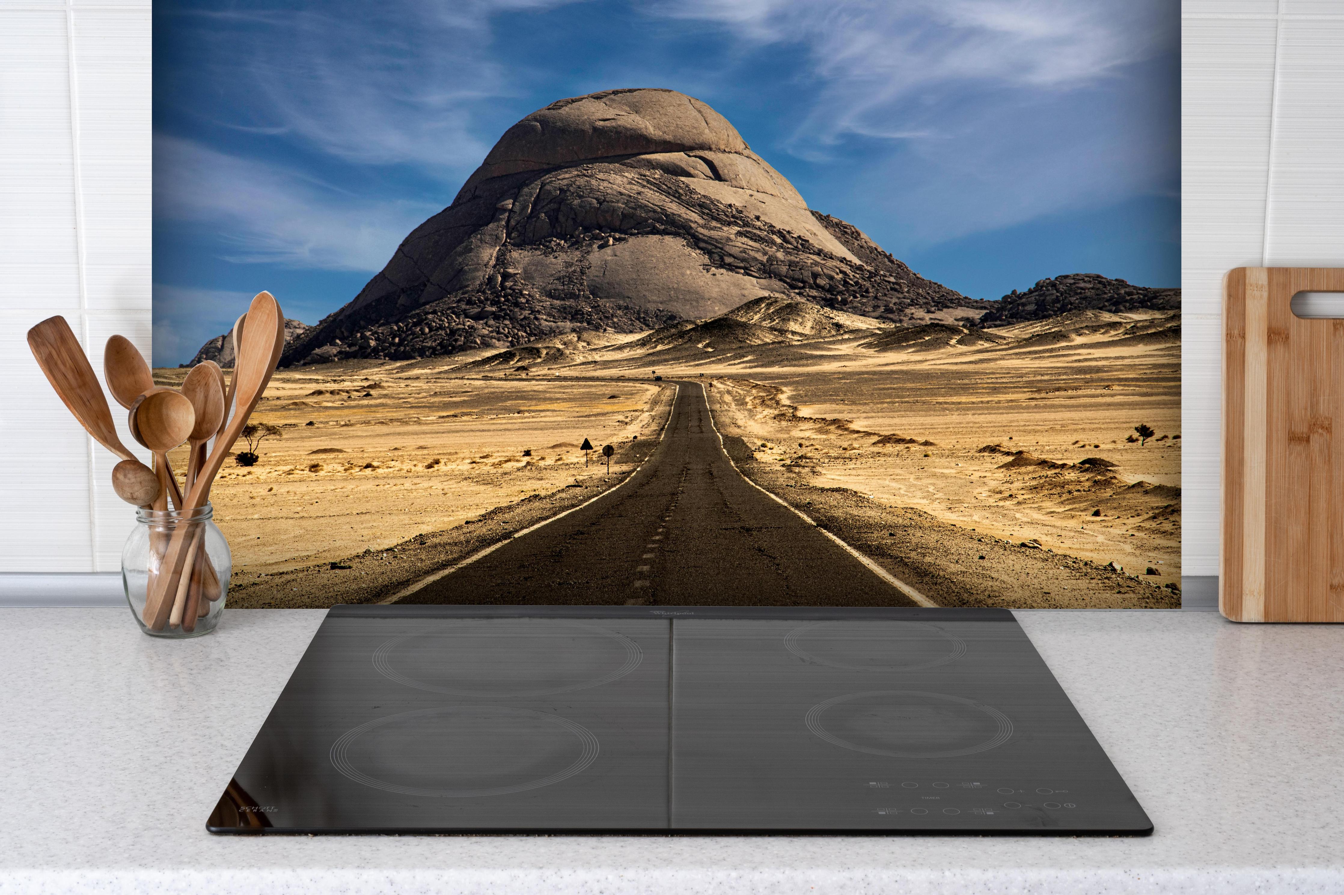 Spritzschutz - Weg durch Wüstenlandschaft zum Berg hinter einem Cerankochfeld zwischen Holz-Kochutensilien
