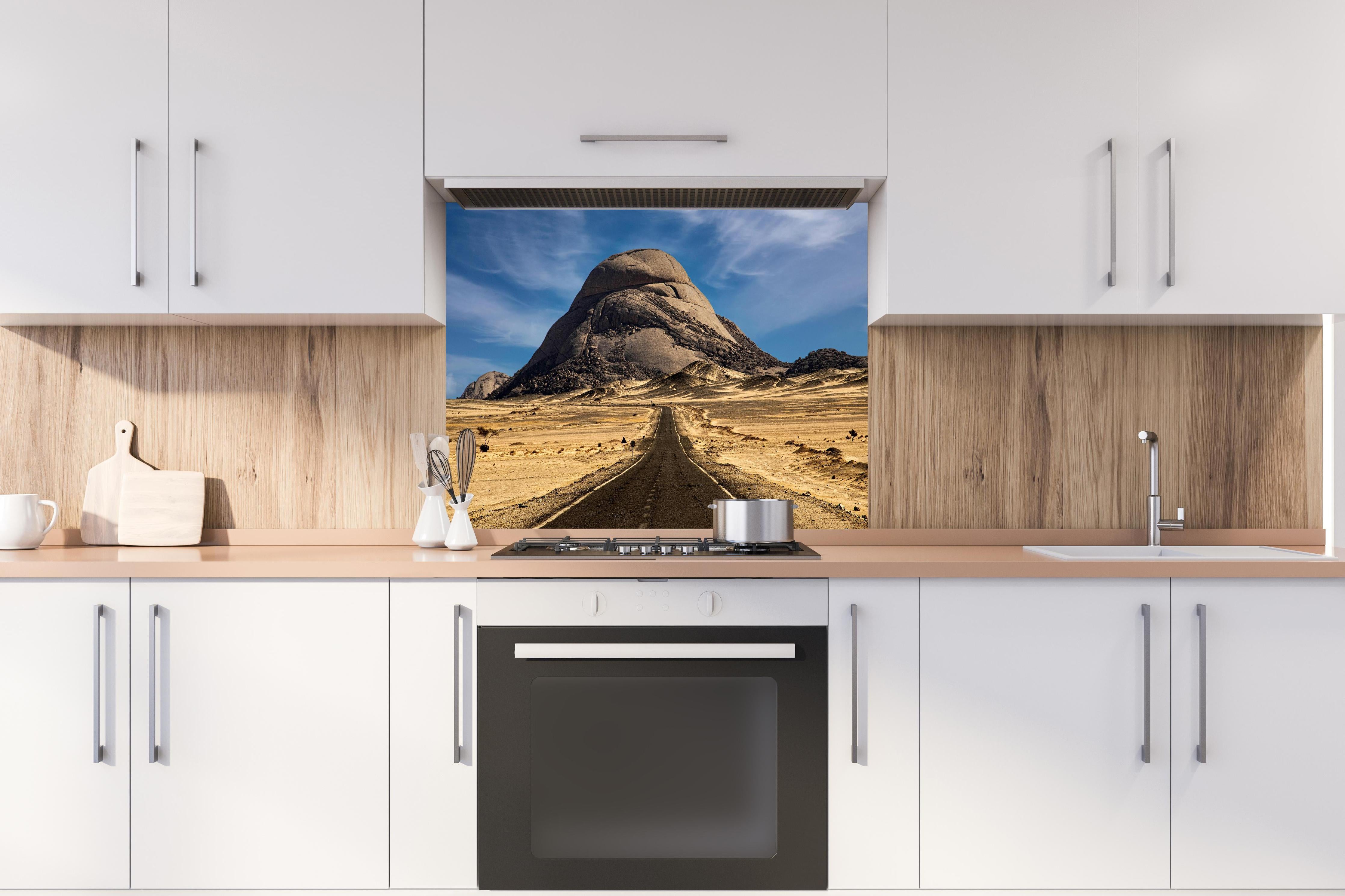 Spritzschutz - Weg durch Wüstenlandschaft zum Berg hinter einem Cerankochfeld zwischen Holz-Kochutensilien
