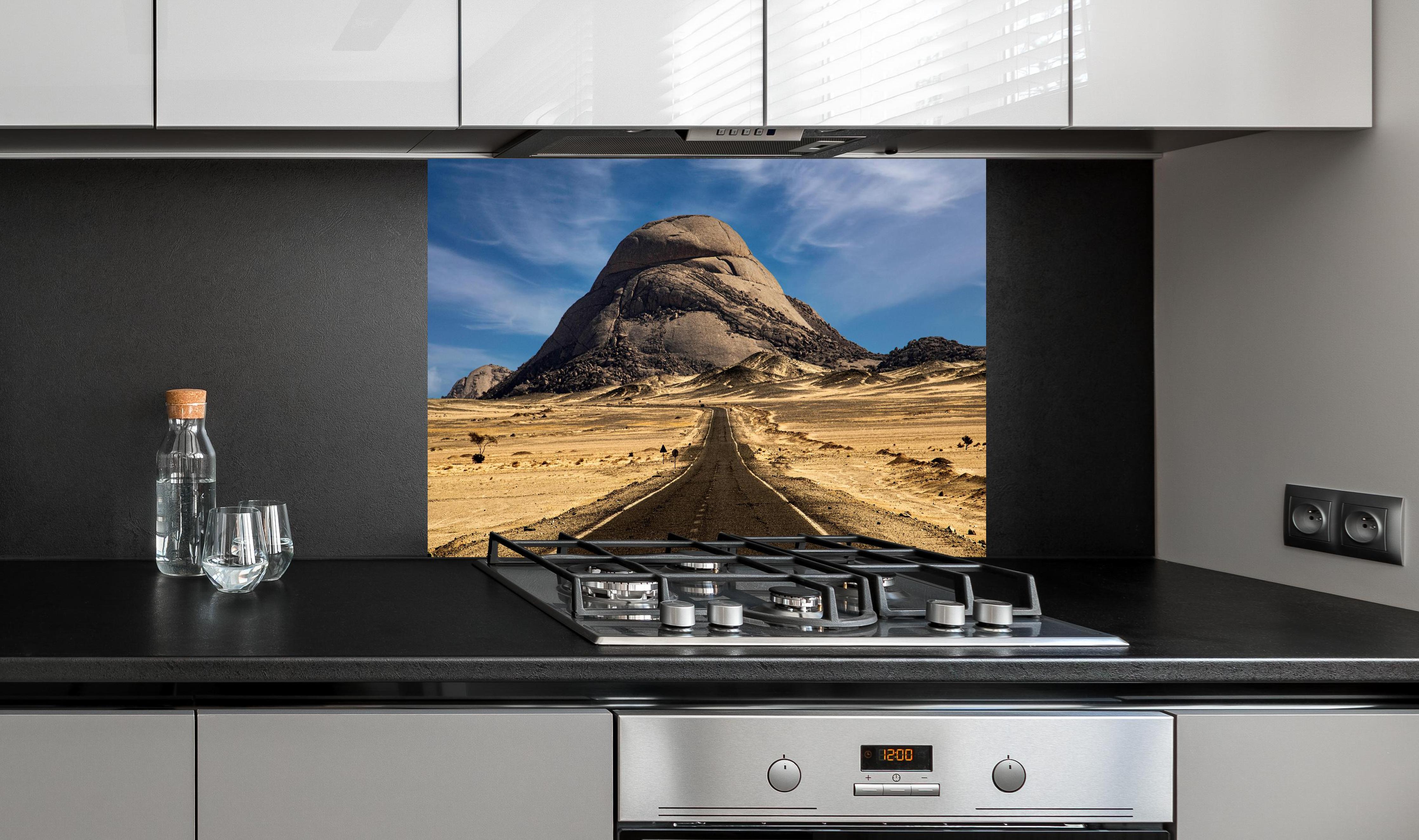 Spritzschutz - Weg durch Wüstenlandschaft zum Berg hinter einem Cerankochfeld zwischen Holz-Kochutensilien
