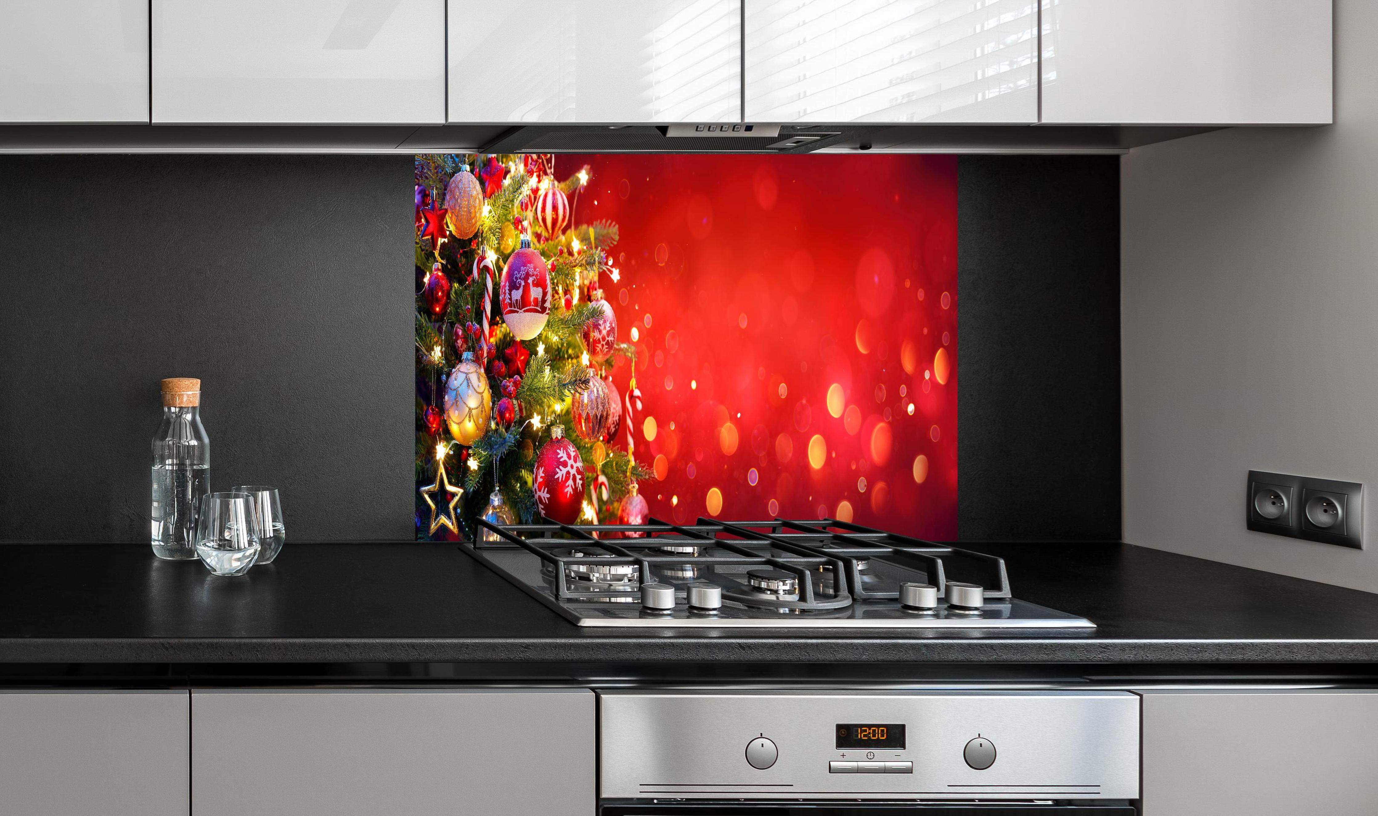 Spritzschutz - Weihnachtsbaum hinter einem Cerankochfeld zwischen Holz-Kochutensilien
