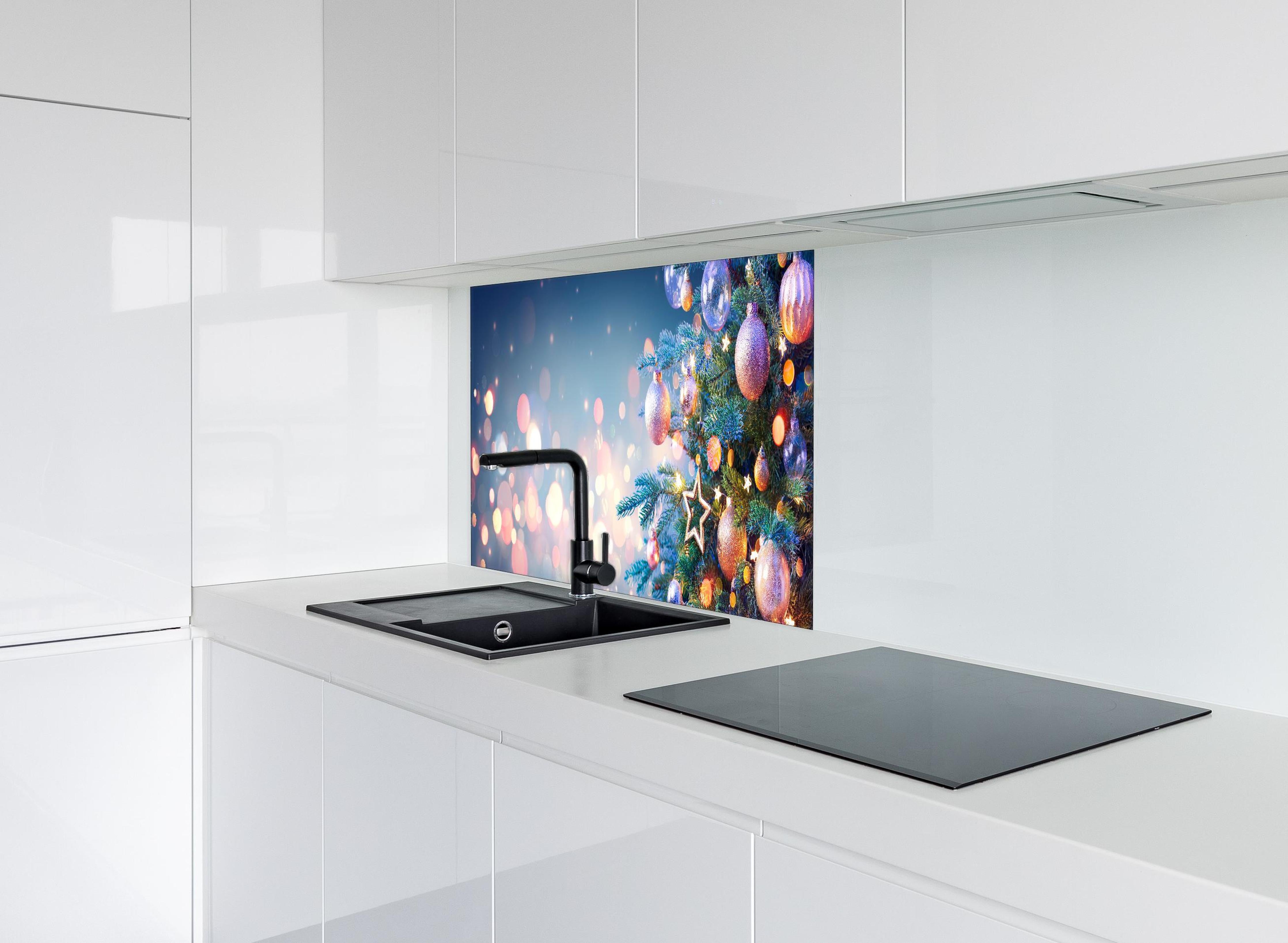 Spritzschutz - Weihnachtsbaum mit bunten Kugeln hinter einem Cerankochfeld zwischen Holz-Kochutensilien
