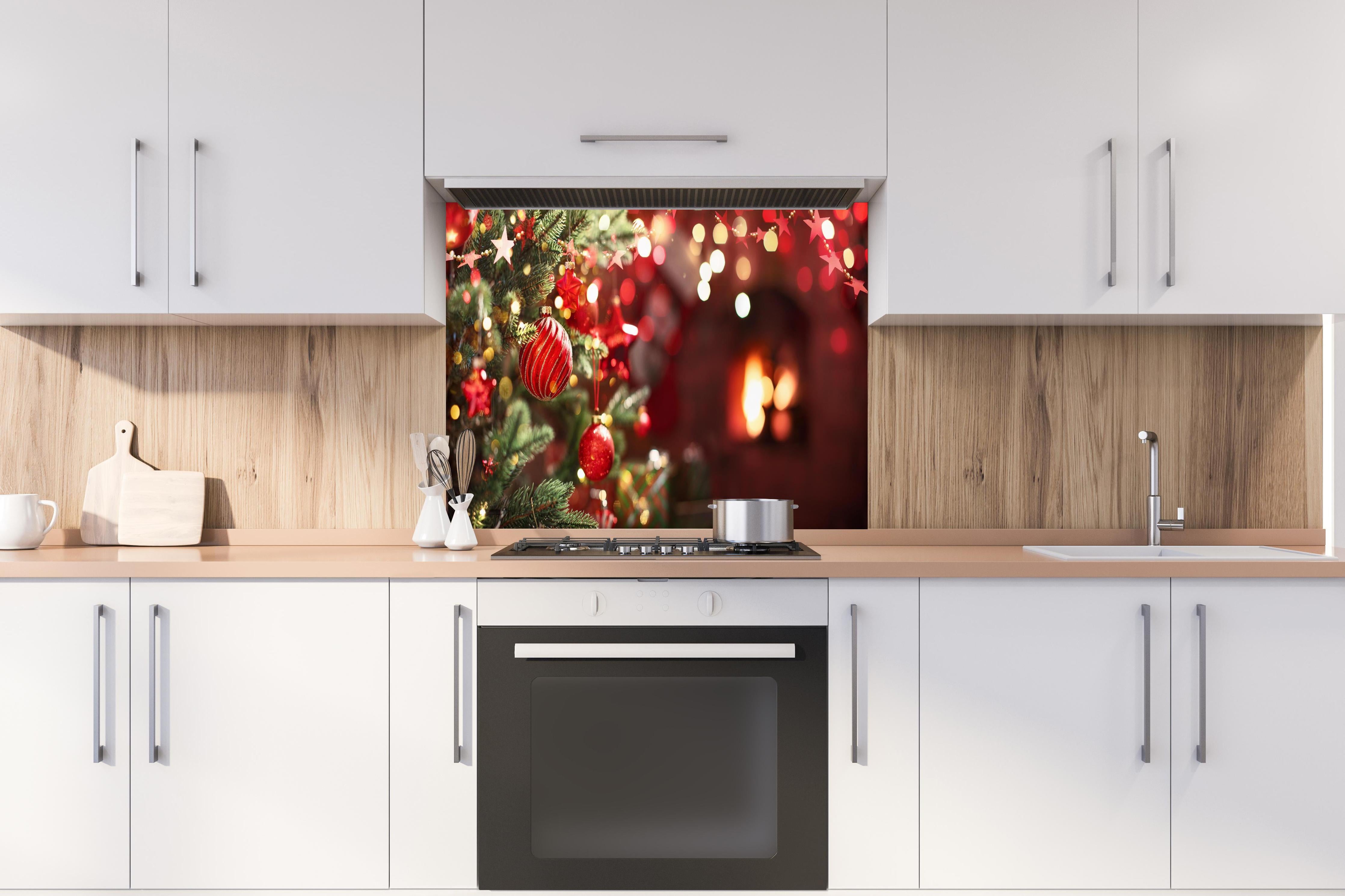 Spritzschutz - Weihnachtsbaum mit roten Kugeln und Sternen hinter einem Cerankochfeld zwischen Holz-Kochutensilien
