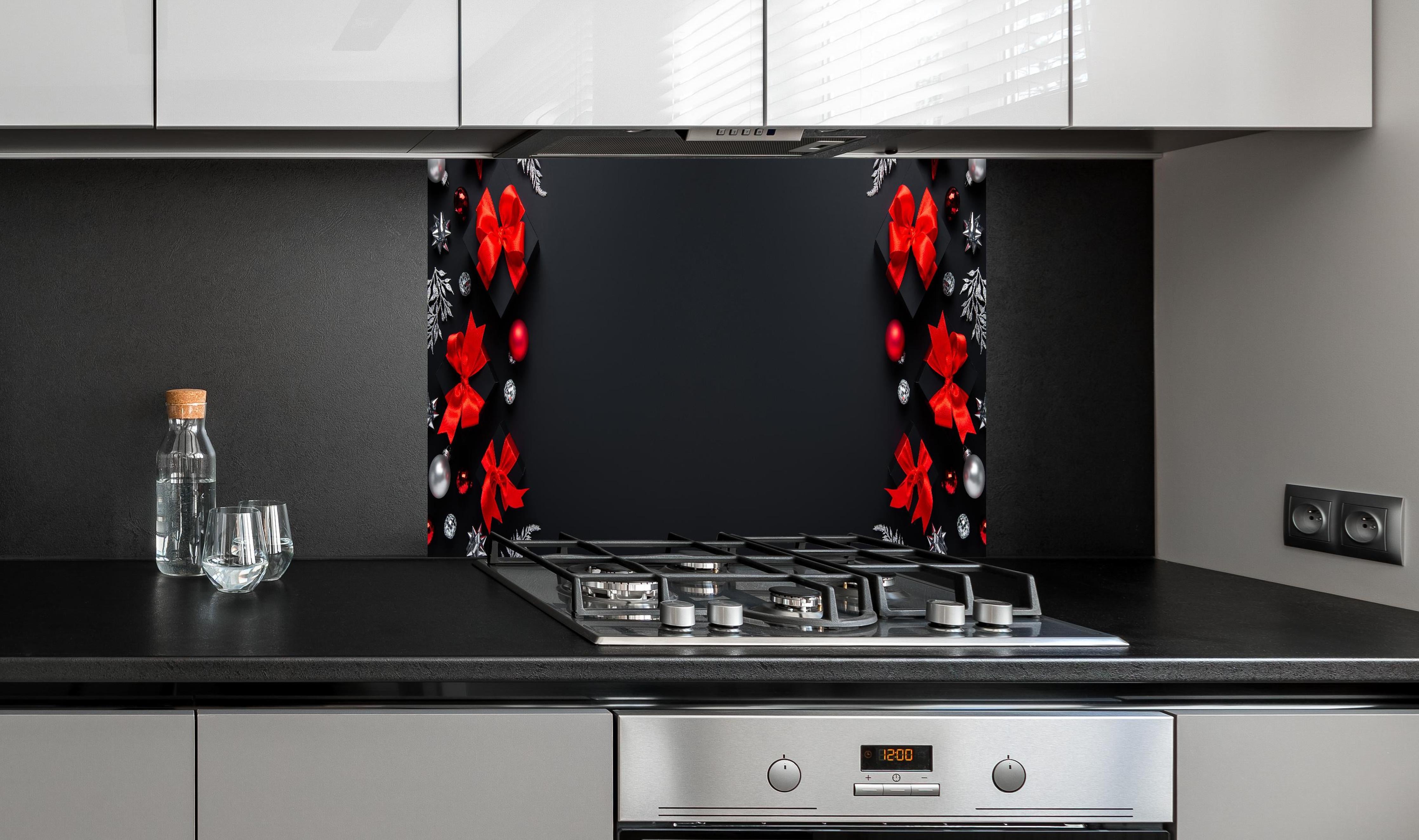 Spritzschutz - Weihnachtsdeko als Hintergrund hinter einem Cerankochfeld zwischen Holz-Kochutensilien
