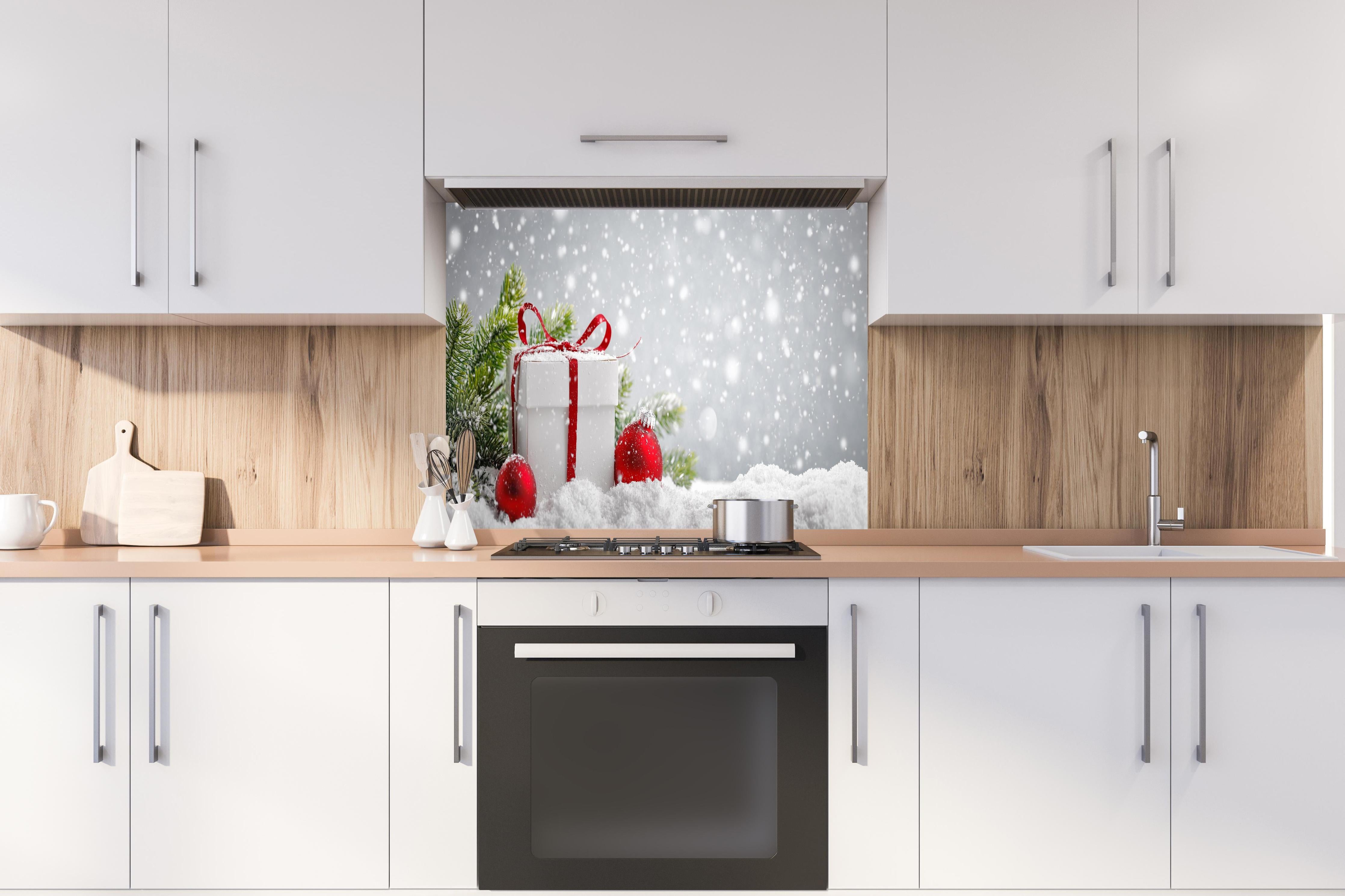 Spritzschutz - Weihnachtsdekoration hinter einem Cerankochfeld zwischen Holz-Kochutensilien
