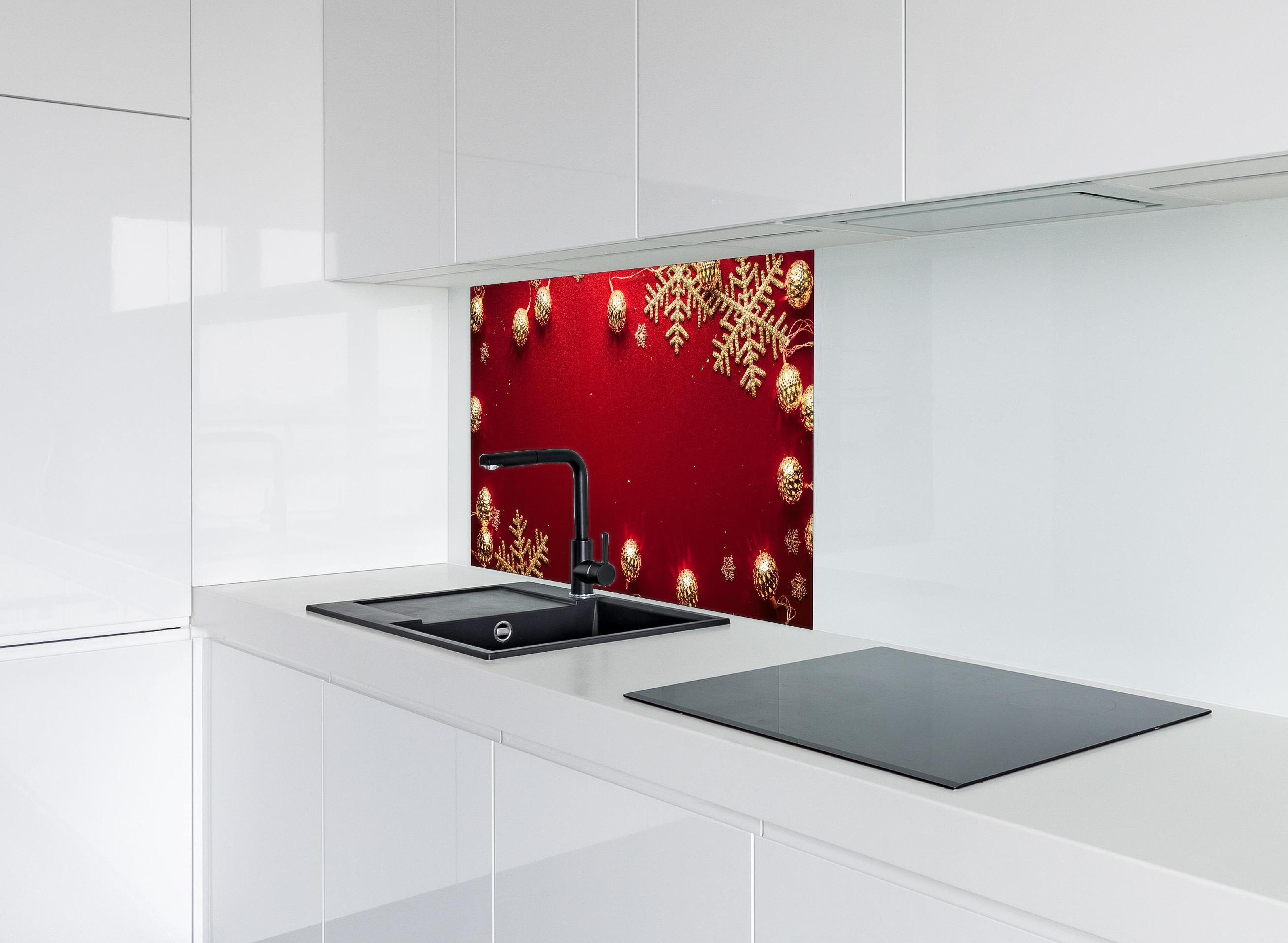 Spritzschutz - Weihnachtsdekoration auf rotem Hintergrund hinter einem Cerankochfeld zwischen Holz-Kochutensilien
