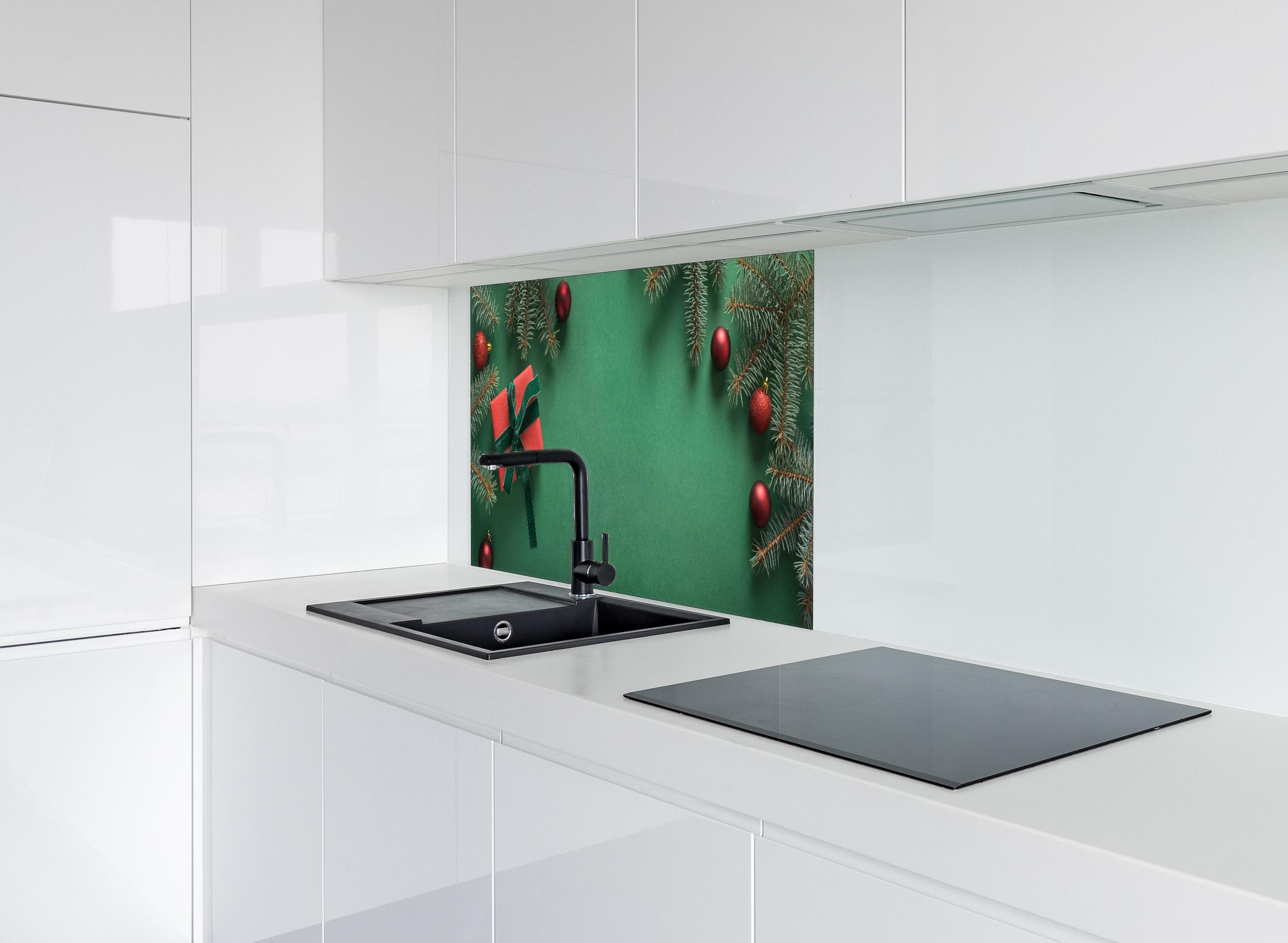 Spritzschutz - Weihnachtsrahmen auf grünem Hintergrund hinter einem Cerankochfeld zwischen Holz-Kochutensilien
