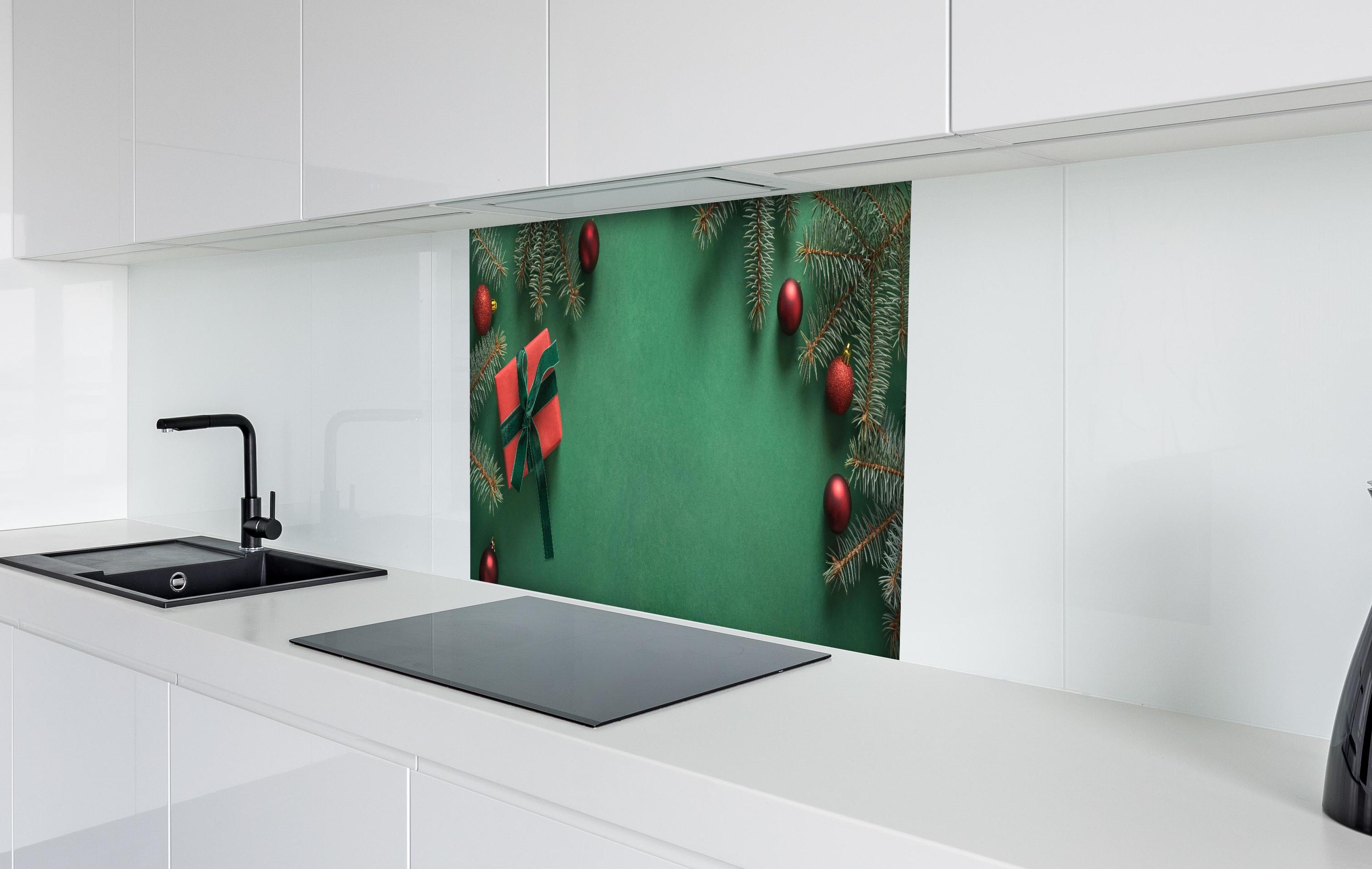 Spritzschutz - Weihnachtsrahmen auf grünem Hintergrund hinter einem Cerankochfeld zwischen Holz-Kochutensilien
