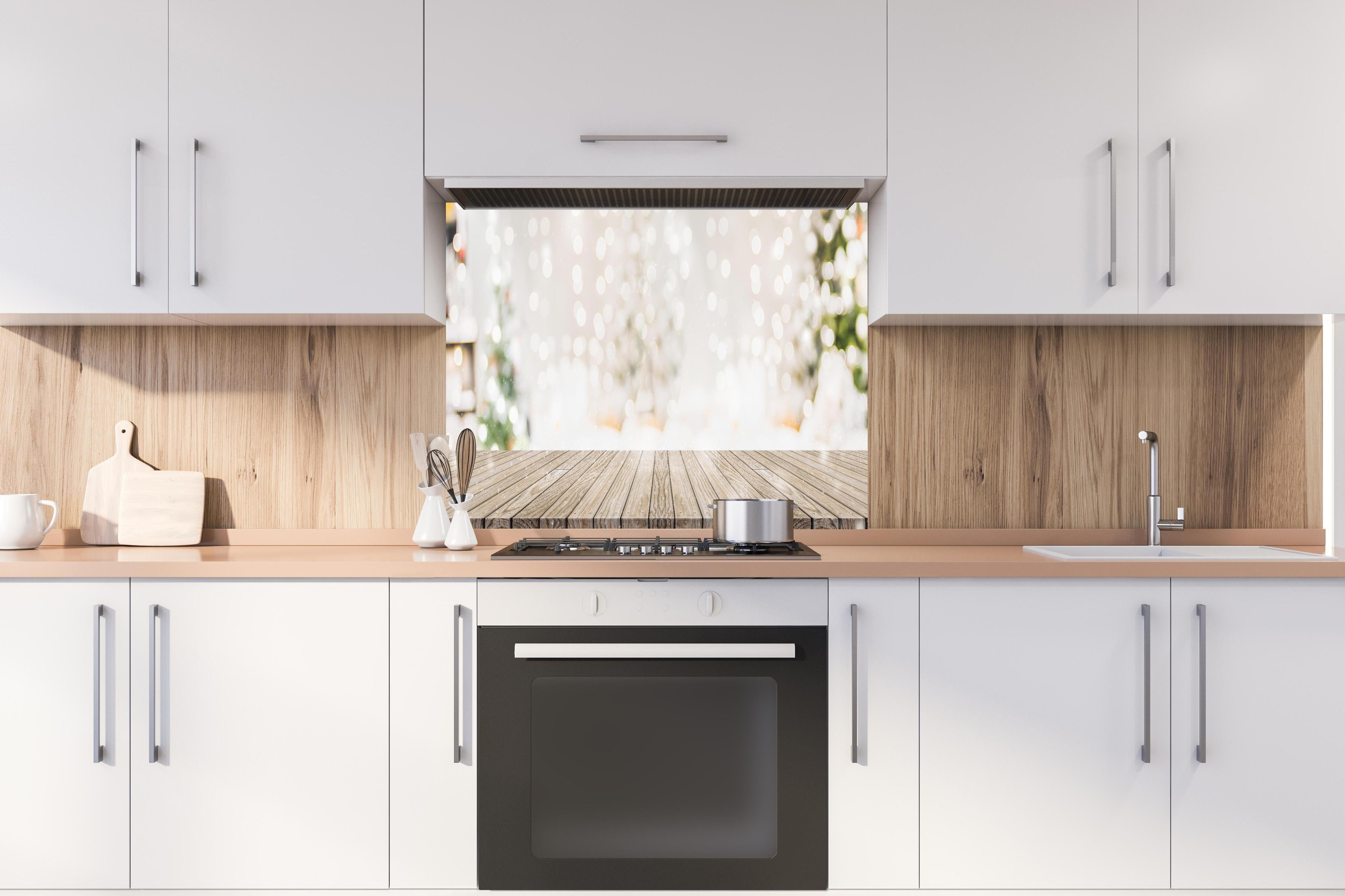 Spritzschutz - Weihnachtstimmung hinter einem Cerankochfeld zwischen Holz-Kochutensilien
