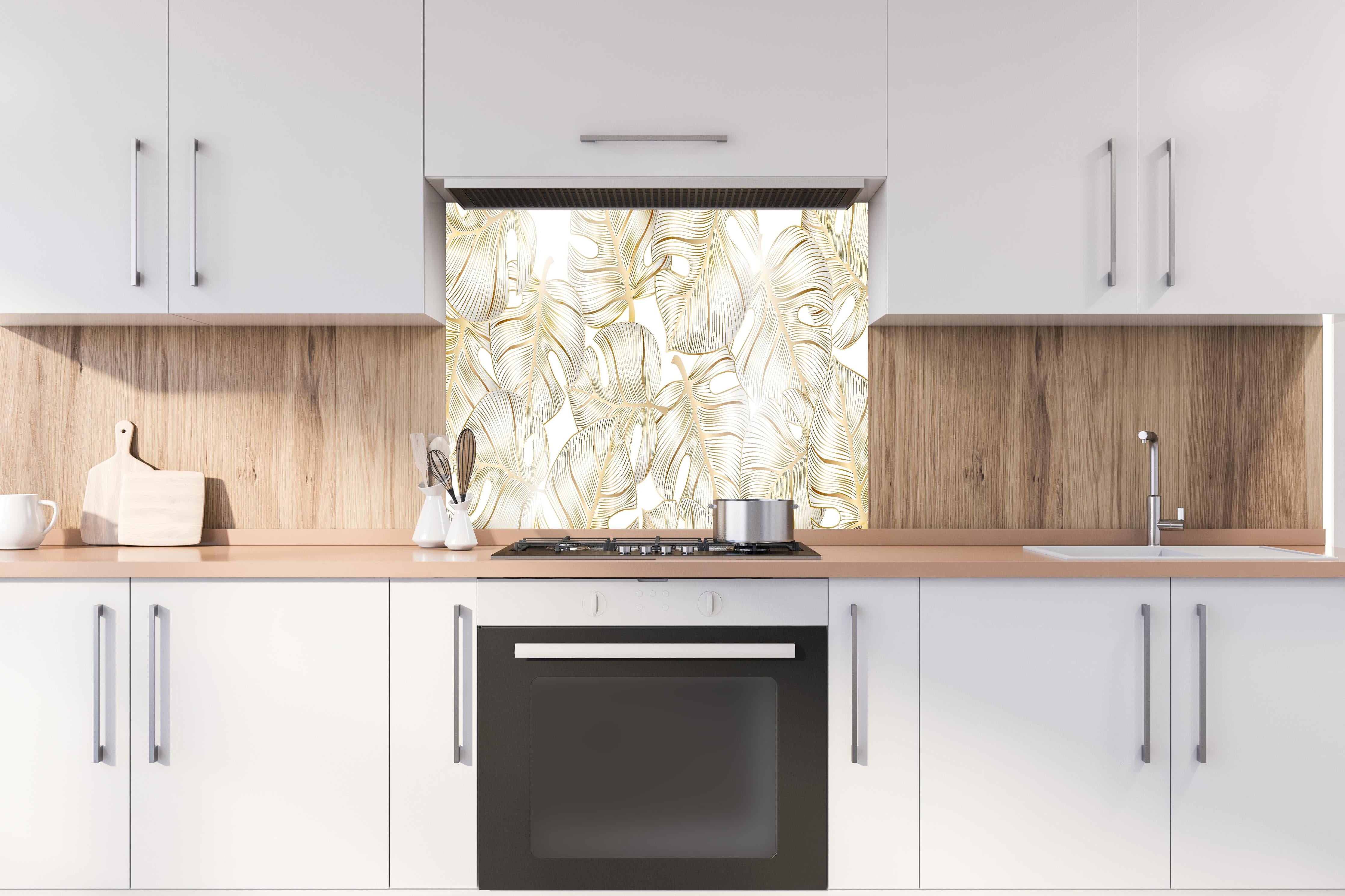 Spritzschutz - Weiß-Goldene Blattmuster Design Struktur hinter einem Cerankochfeld zwischen Holz-Kochutensilien
