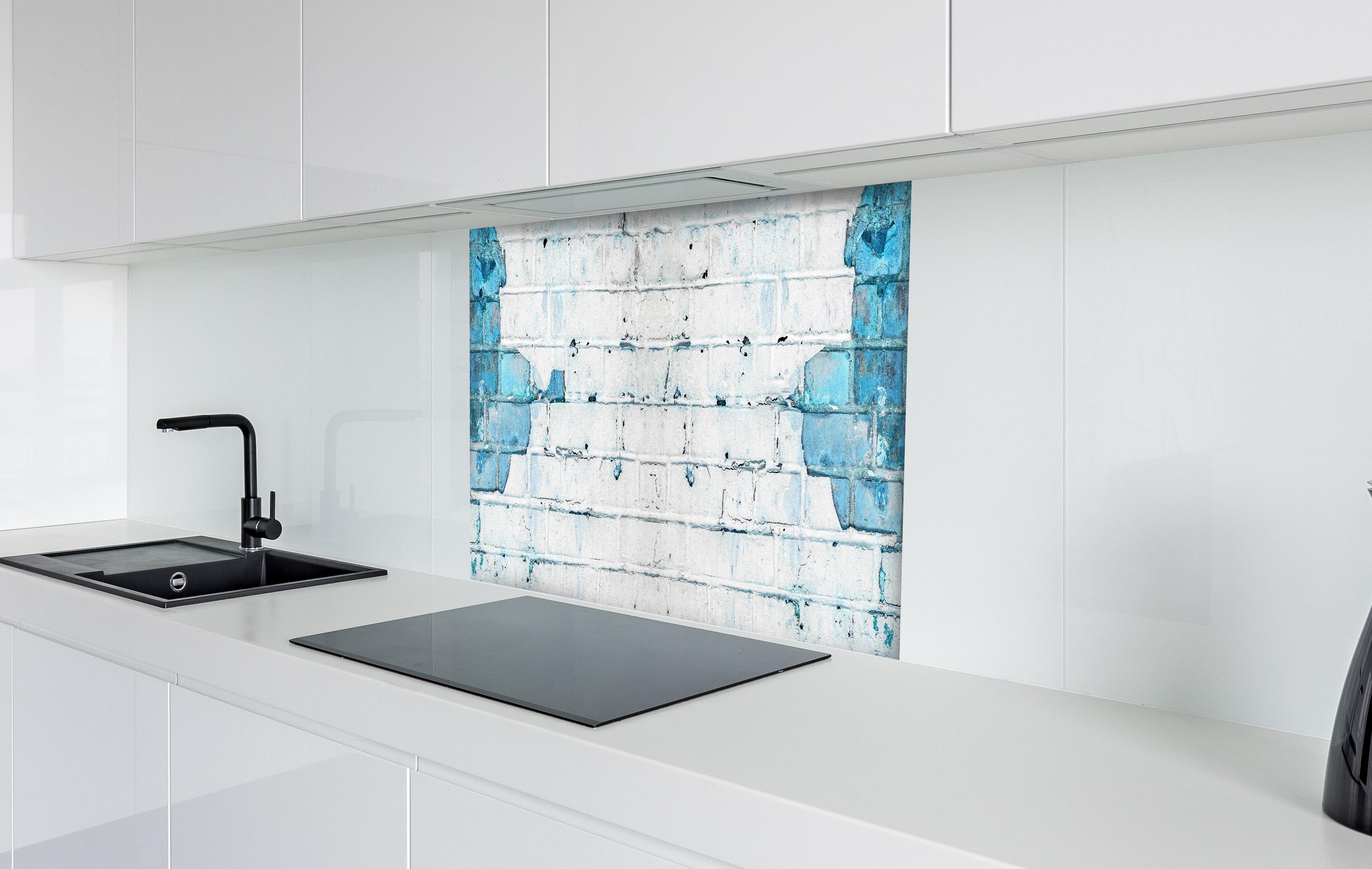 Spritzschutz - Weiß blau beschädigte Backsteinmauer hinter einem Cerankochfeld zwischen Holz-Kochutensilien
