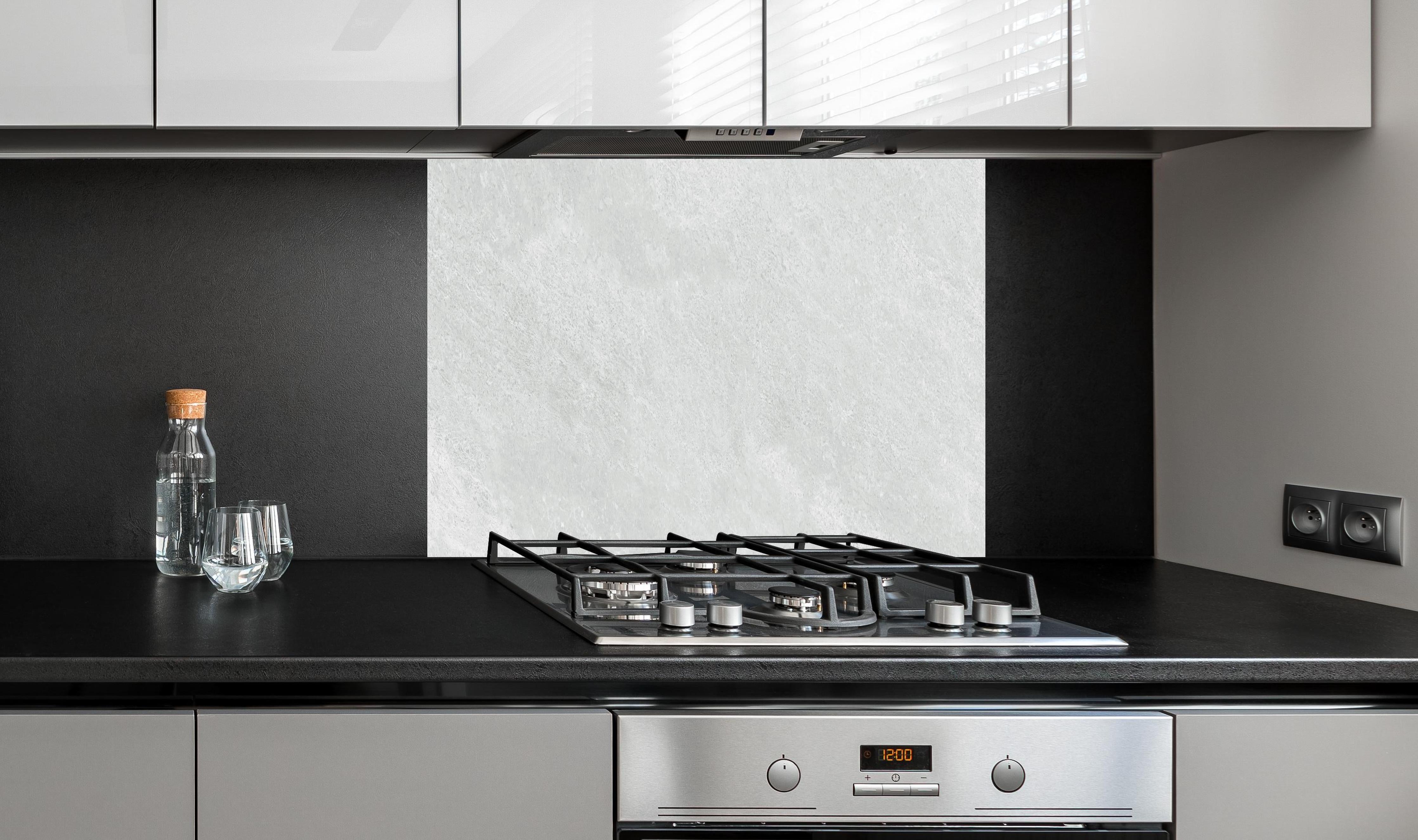 Spritzschutz - Weiße Licht Marmor Textur hinter einem Cerankochfeld zwischen Holz-Kochutensilien
