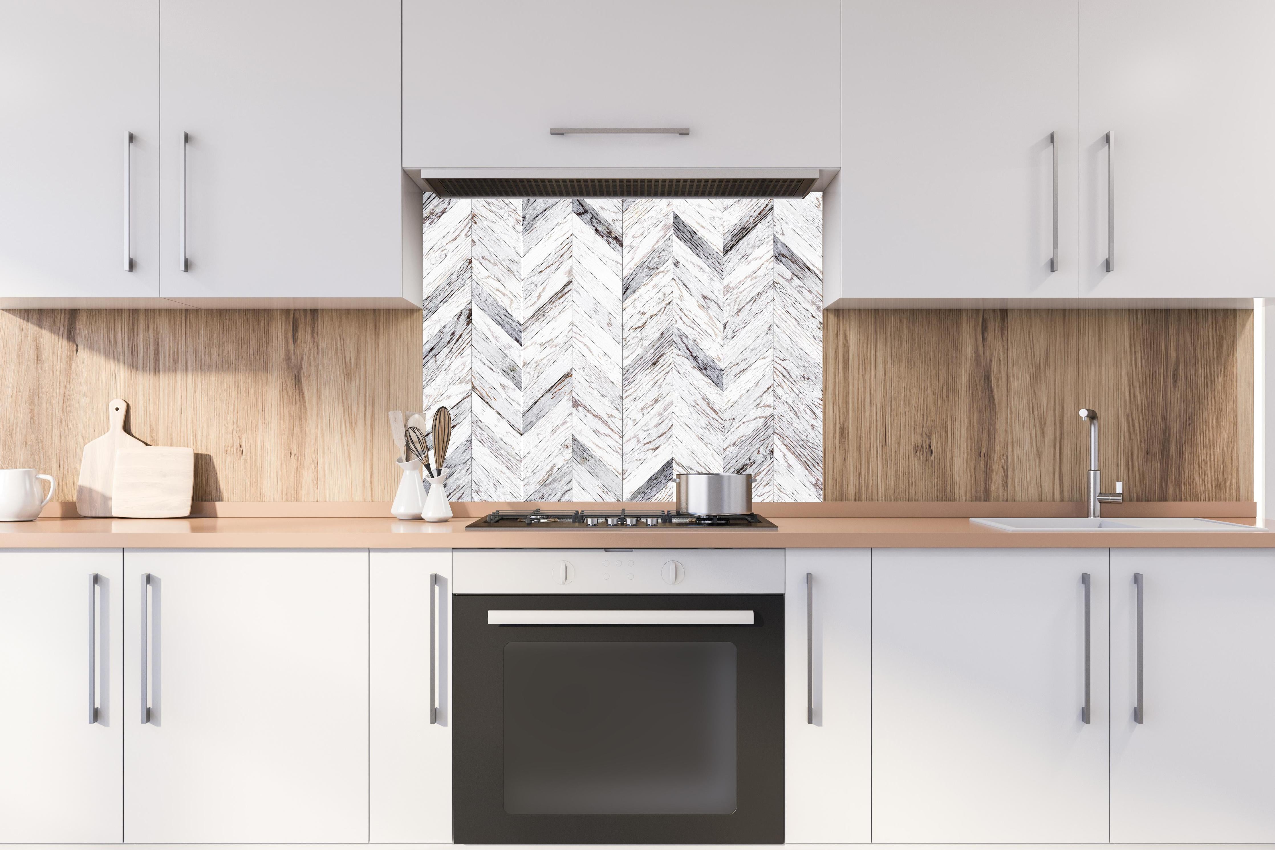 Spritzschutz - Weißer Chevron - Holzoptik hinter einem Cerankochfeld zwischen Holz-Kochutensilien
