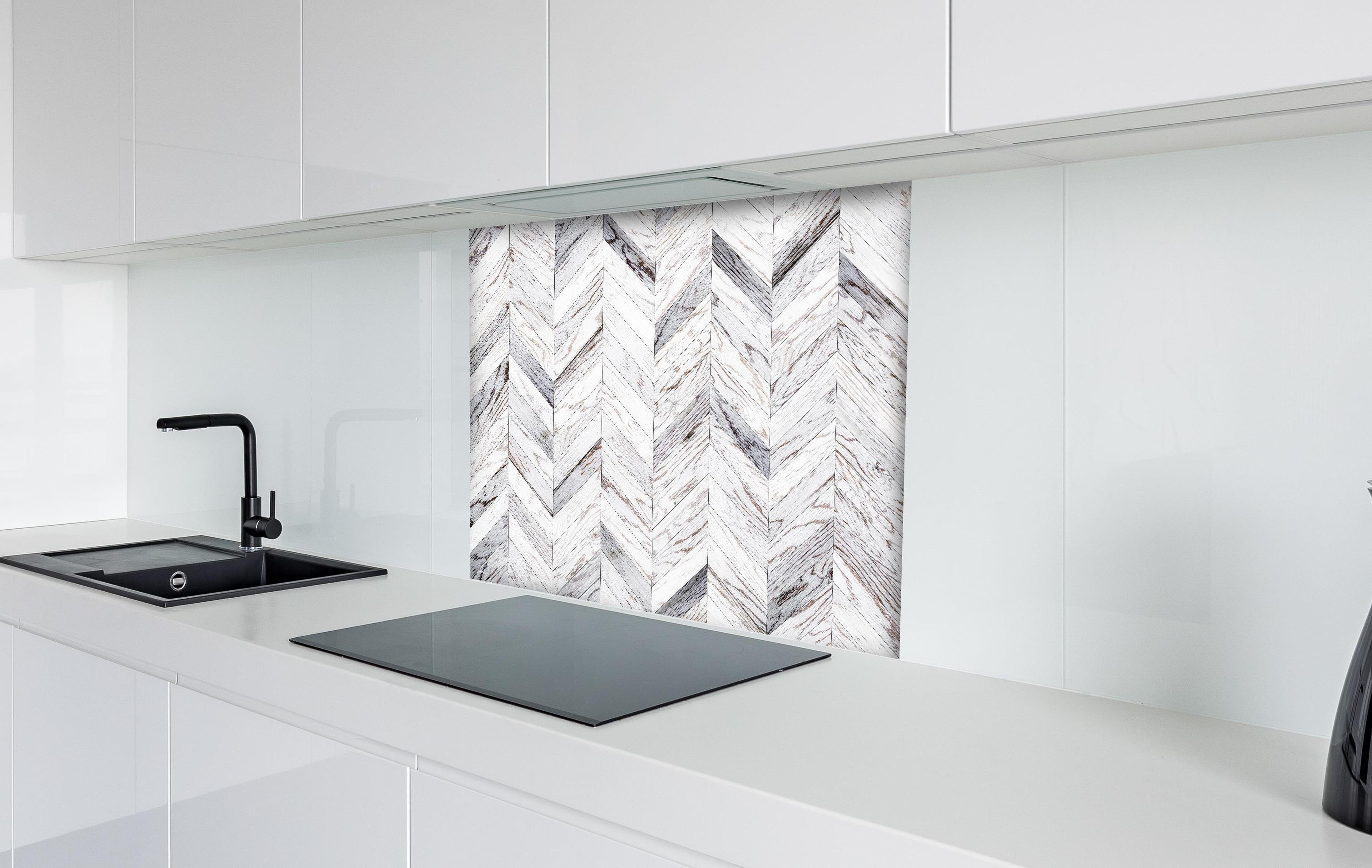 Spritzschutz - Weißer Chevron - Holzoptik hinter einem Cerankochfeld zwischen Holz-Kochutensilien
