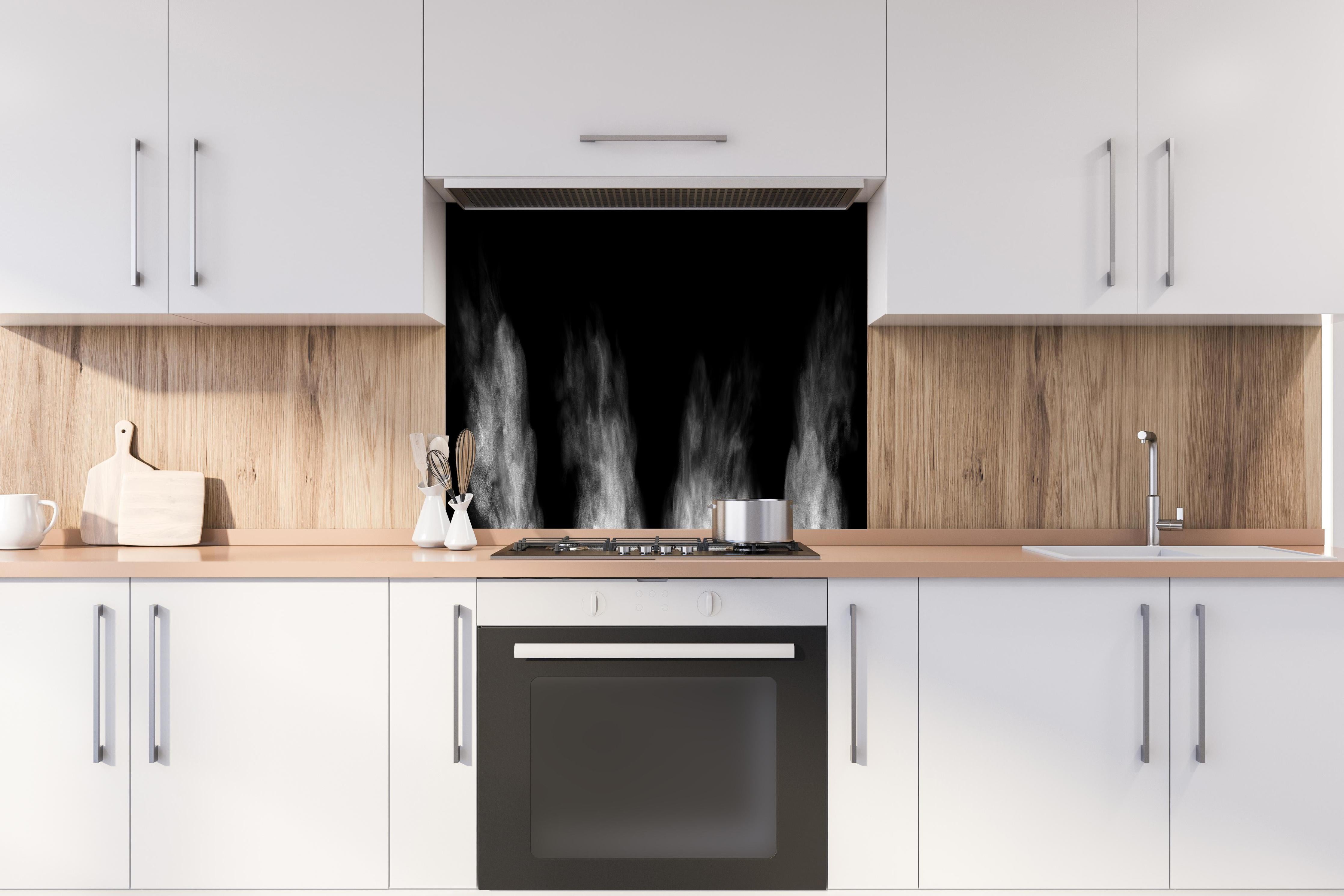 Spritzschutz - Weißer Dampf hinter einem Cerankochfeld zwischen Holz-Kochutensilien
