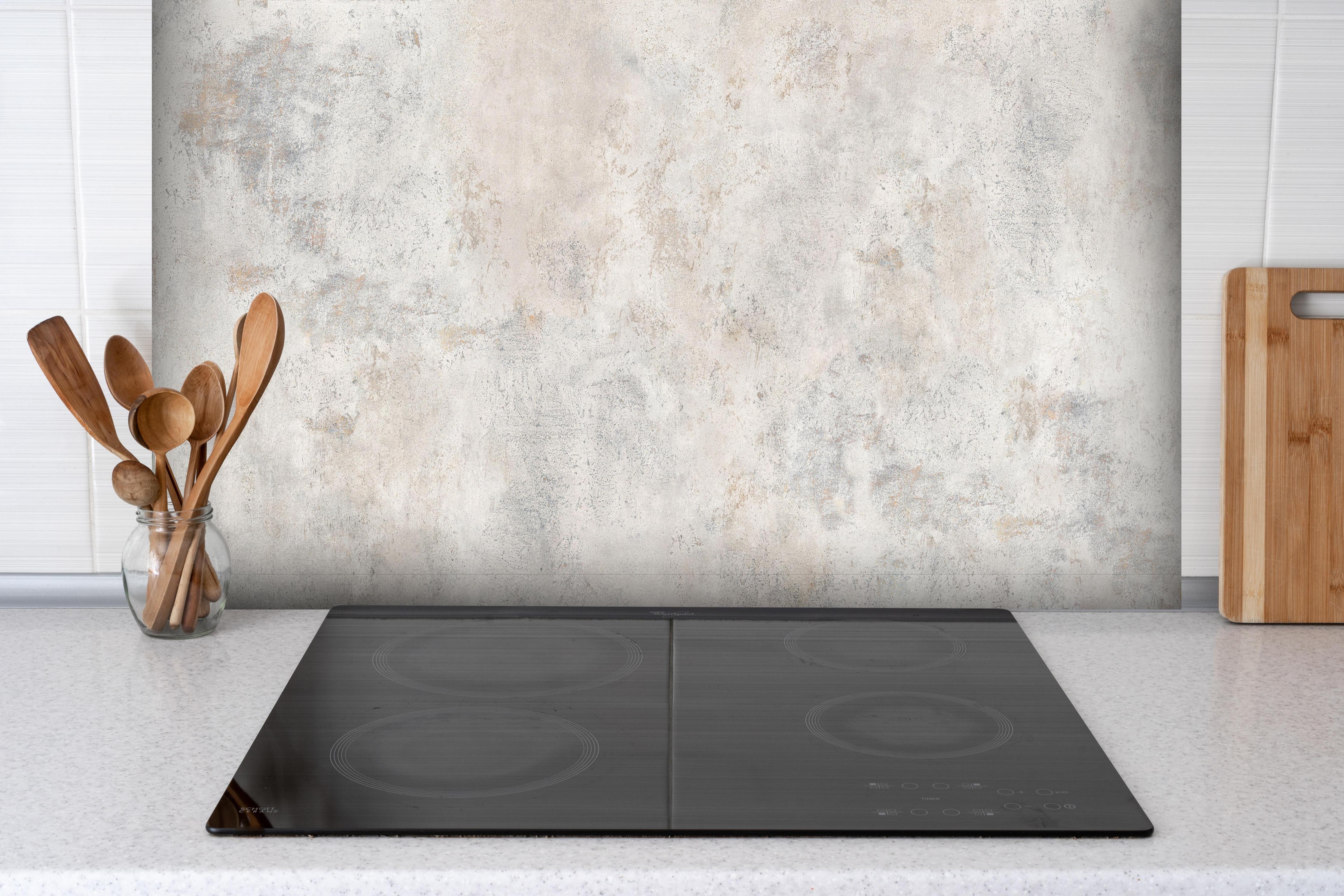 Spritzschutz - Weißer abgenutzter Marmor hinter einem Cerankochfeld zwischen Holz-Kochutensilien
