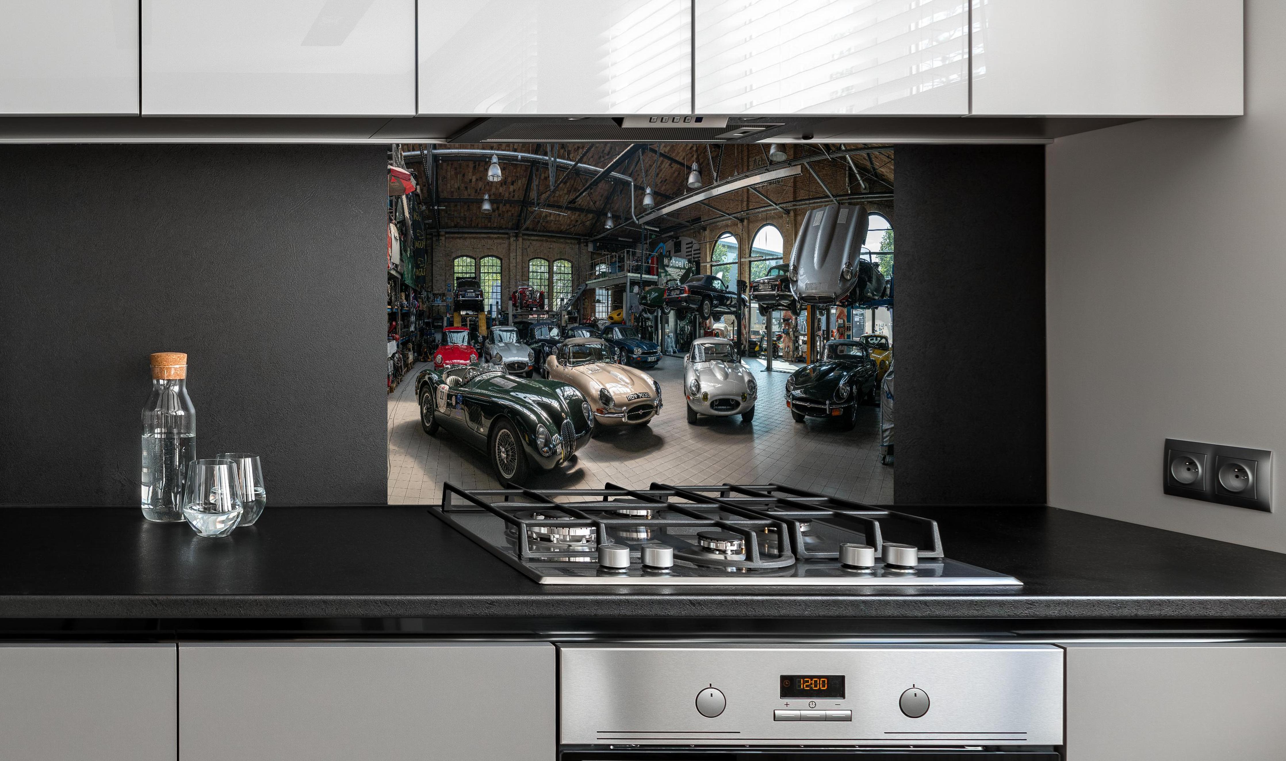 Spritzschutz - Werkstatt für die Reparatur und Wartung englischer Retro-Klassiker hinter einem Cerankochfeld zwischen Holz-Kochutensilien
