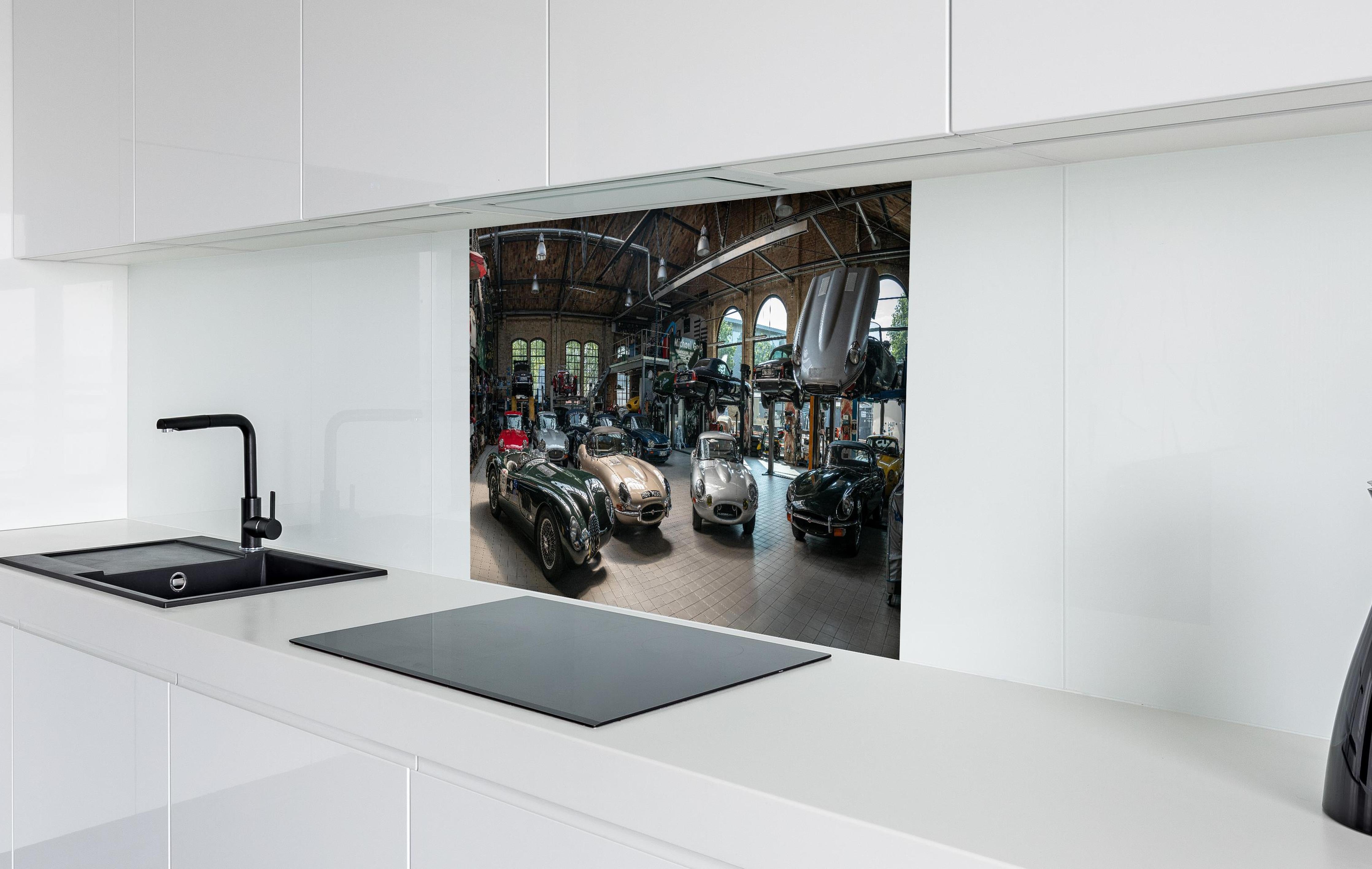 Spritzschutz - Werkstatt für die Reparatur und Wartung englischer Retro-Klassiker hinter einem Cerankochfeld zwischen Holz-Kochutensilien
