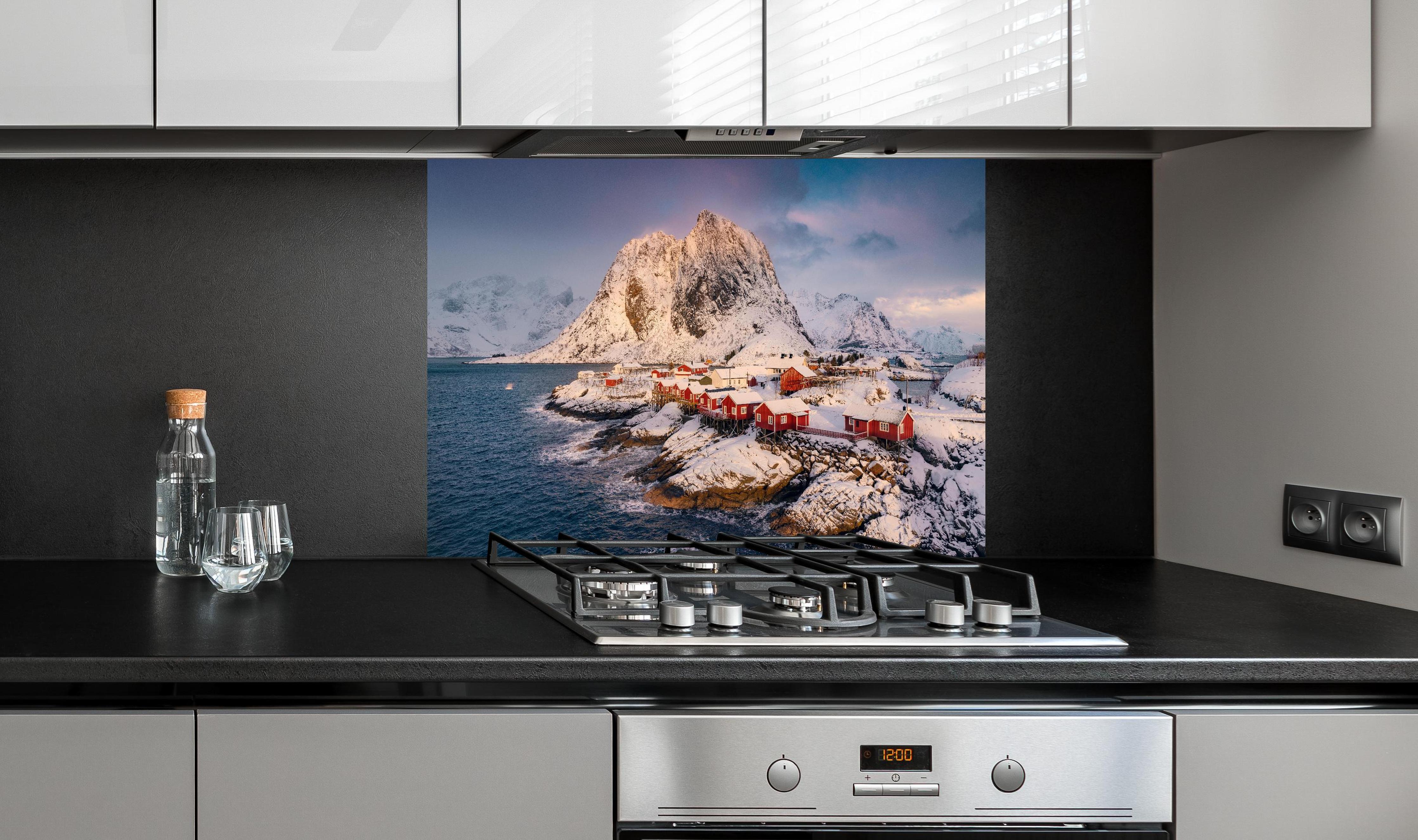 Spritzschutz - Winterlandschaft Lofoten, Schneebedeckte Fjorde hinter einem Cerankochfeld zwischen Holz-Kochutensilien
