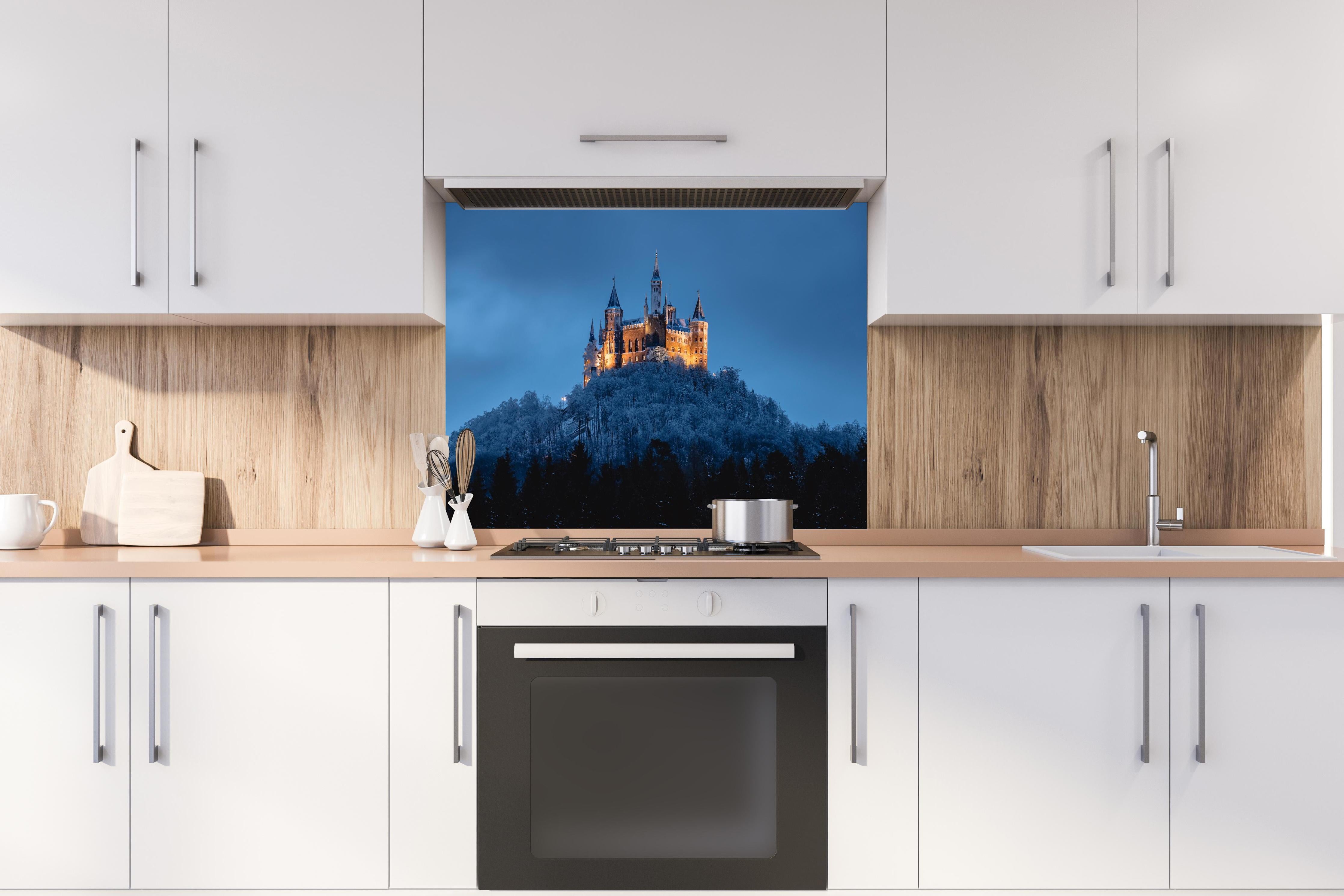 Spritzschutz - Winterliche Atmosphäre - Burg von Hohenzollern hinter einem Cerankochfeld zwischen Holz-Kochutensilien
