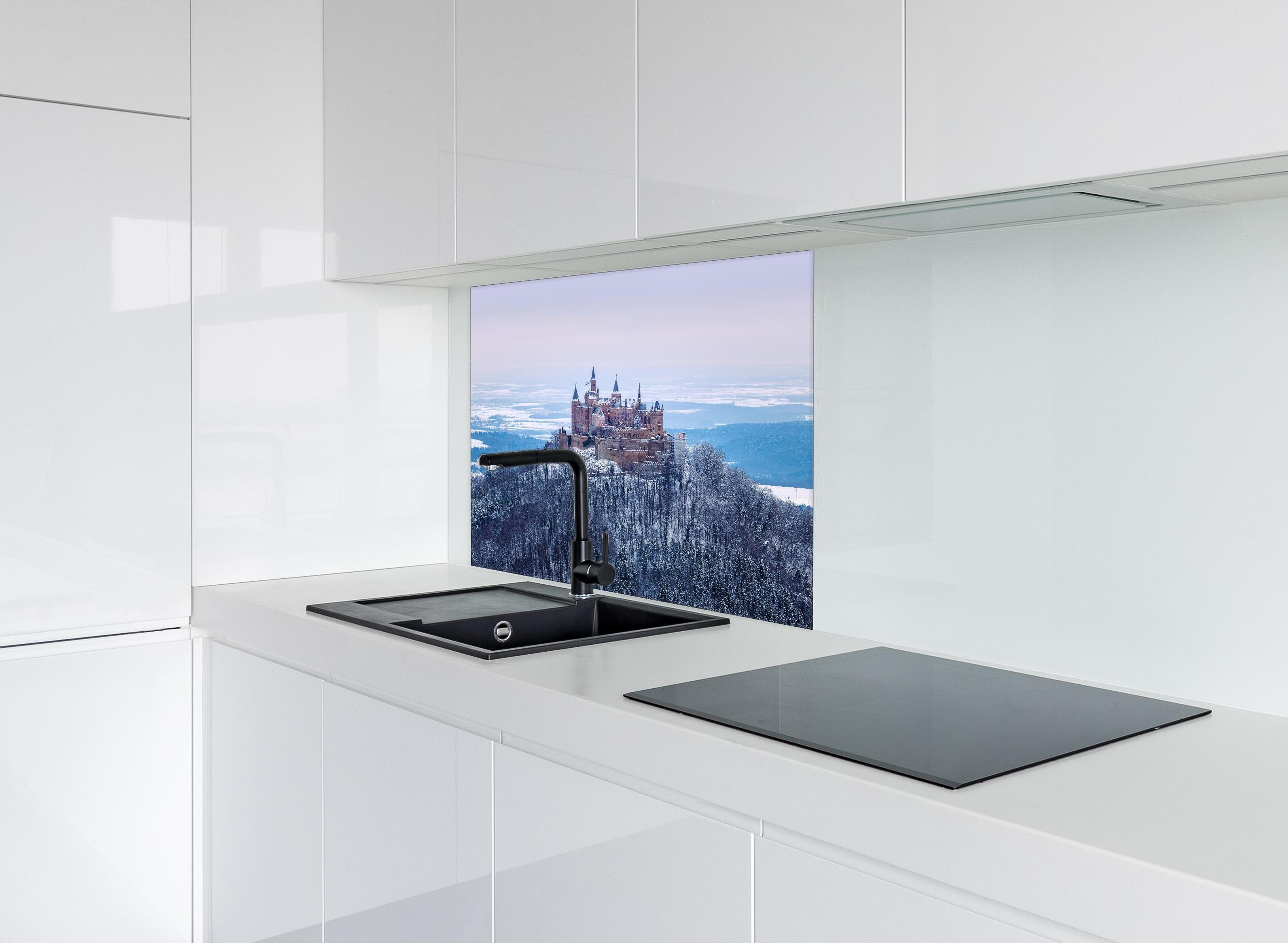 Spritzschutz - Winterliche Burg von Hohenzollern hinter einem Cerankochfeld zwischen Holz-Kochutensilien
