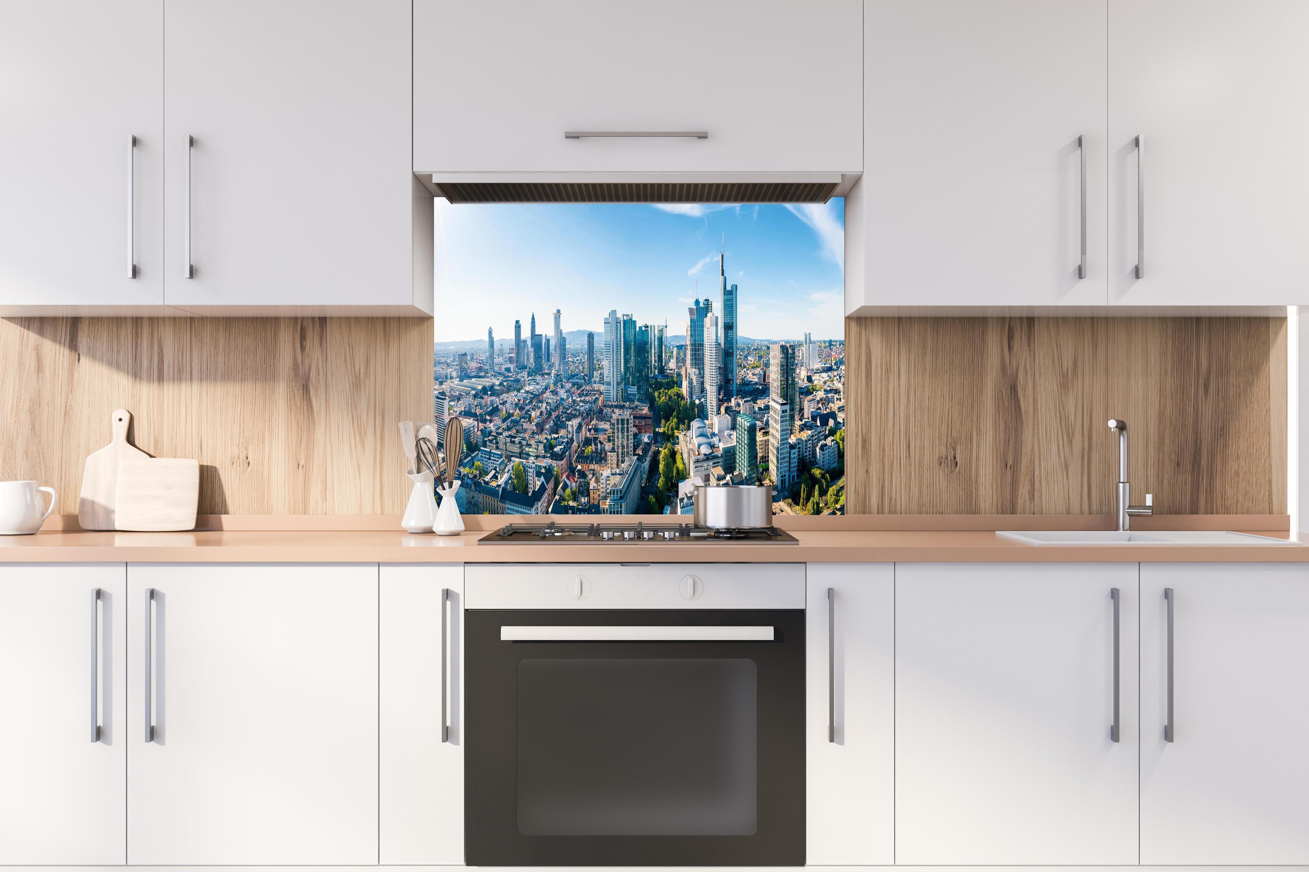 Spritzschutz - Wolkenkratzer -  Frankfurt am Main hinter einem Cerankochfeld zwischen Holz-Kochutensilien
