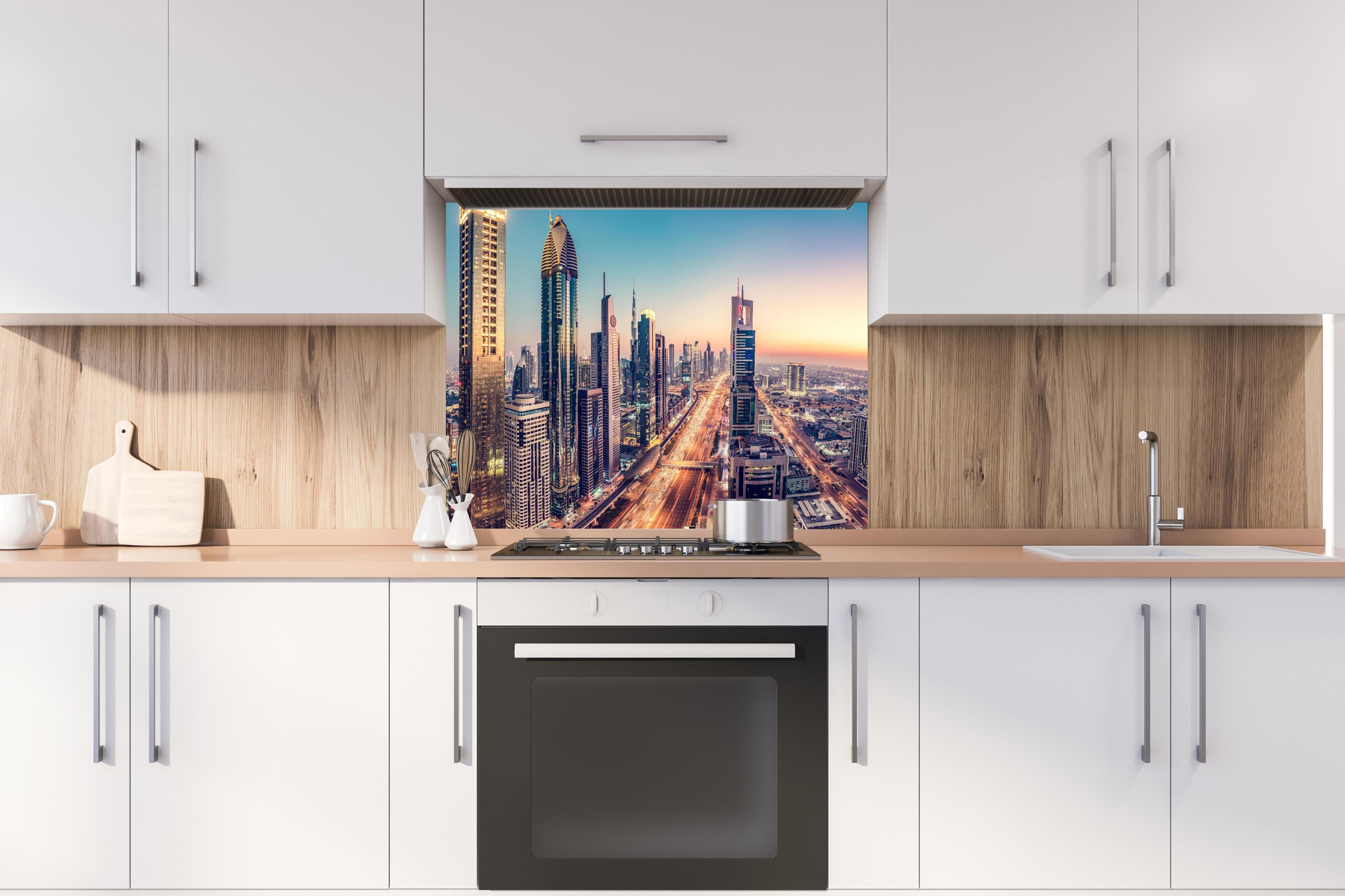 Spritzschutz - Wolkenkratzer - Hochhäuser in der Innenstadt von Dubai hinter einem Cerankochfeld zwischen Holz-Kochutensilien
