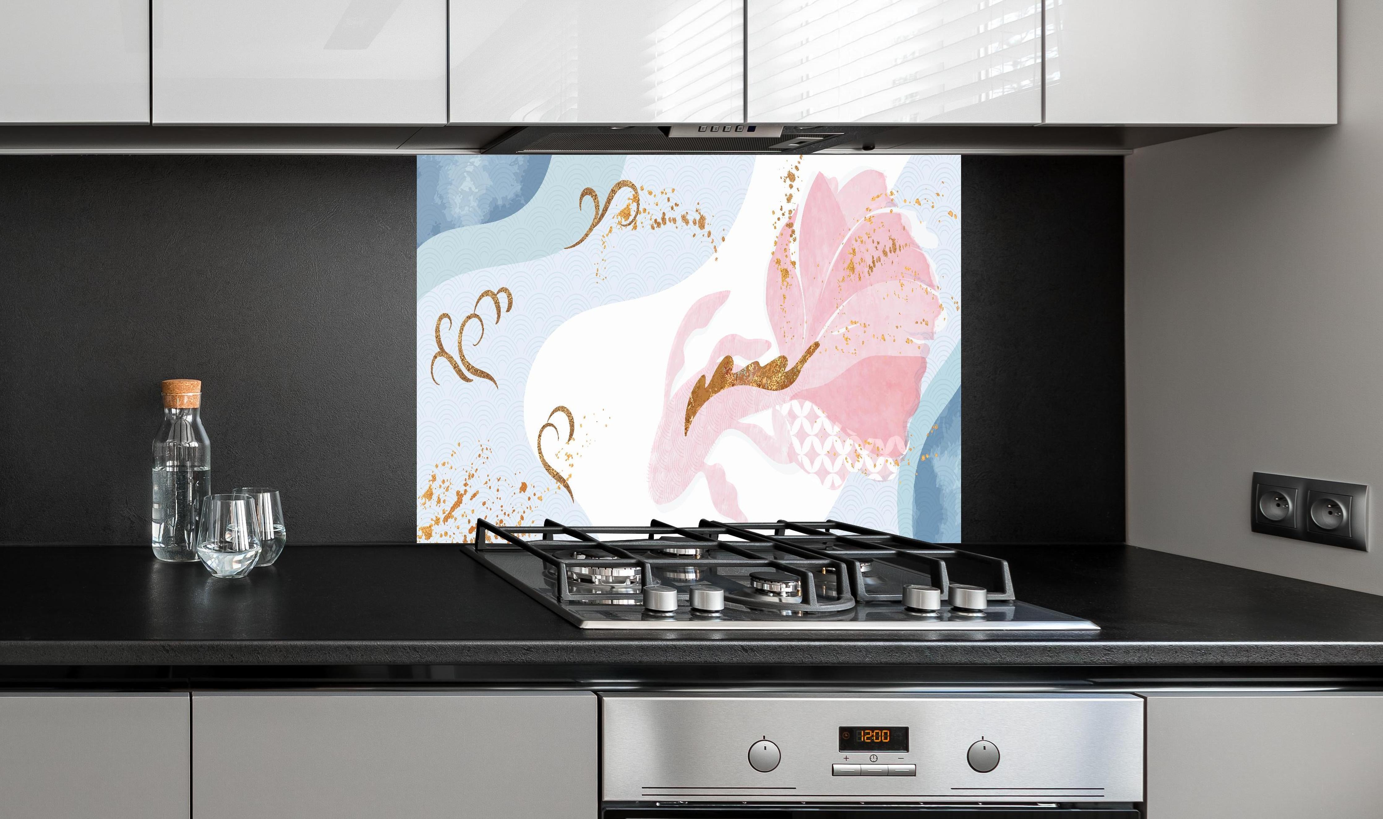 Spritzschutz - Zartes Pastell-Floral mit goldenen Details hinter einem Cerankochfeld zwischen Holz-Kochutensilien
