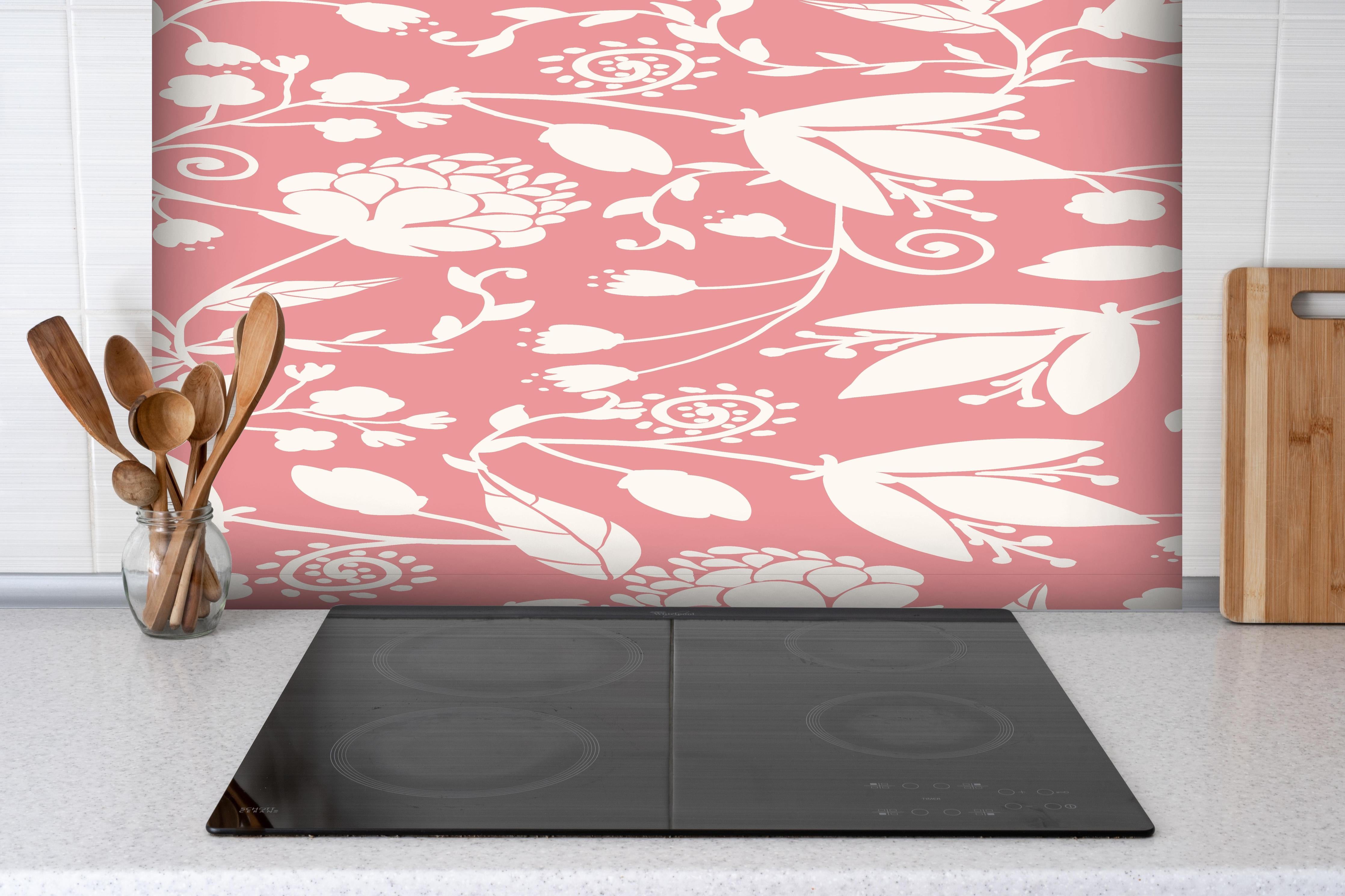 Spritzschutz - Zartes Rosa Blütenmuster für stilvolle Wände hinter einem Cerankochfeld zwischen Holz-Kochutensilien
