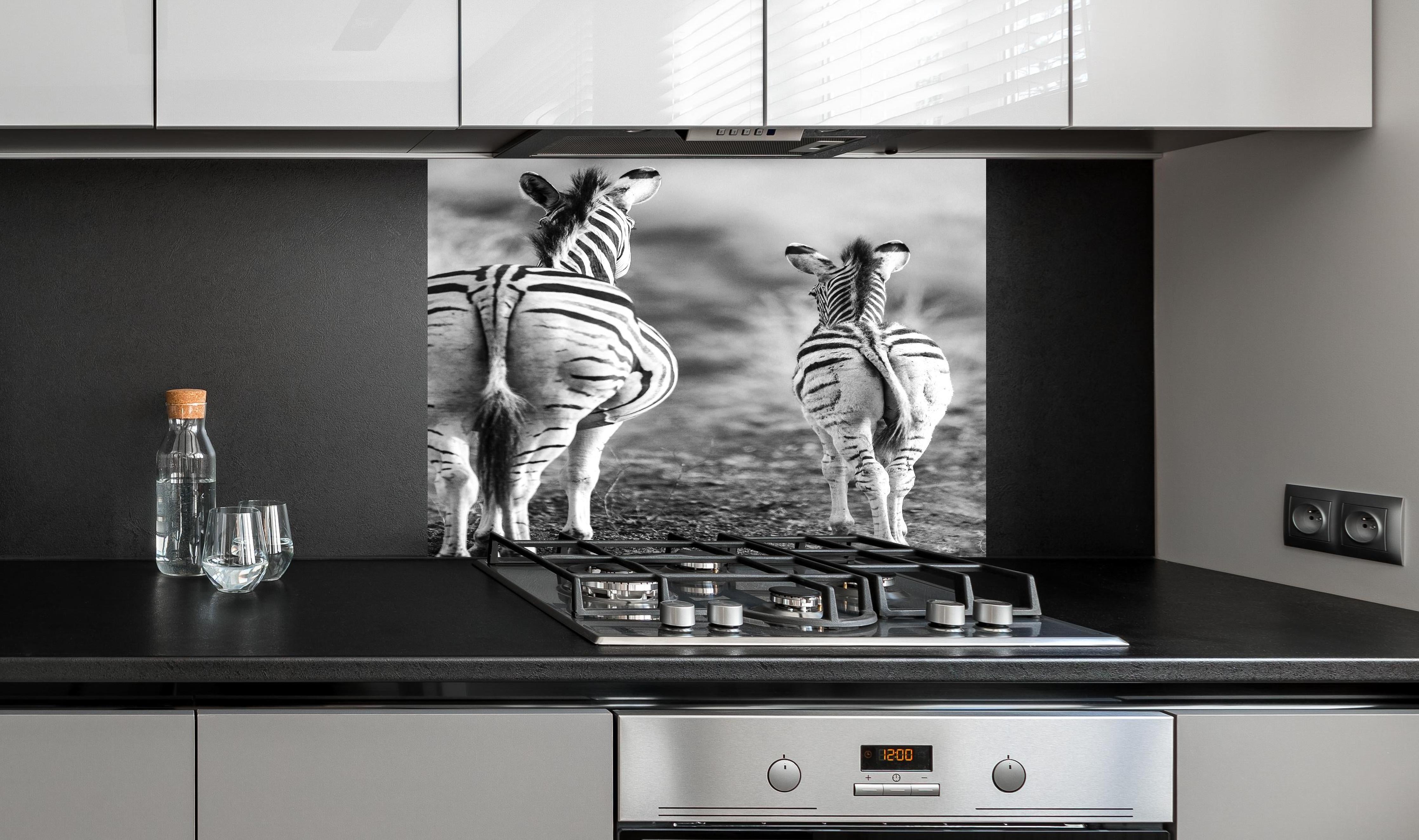 Spritzschutz - Zebra - schwarz-weiß hinter einem Cerankochfeld zwischen Holz-Kochutensilien
