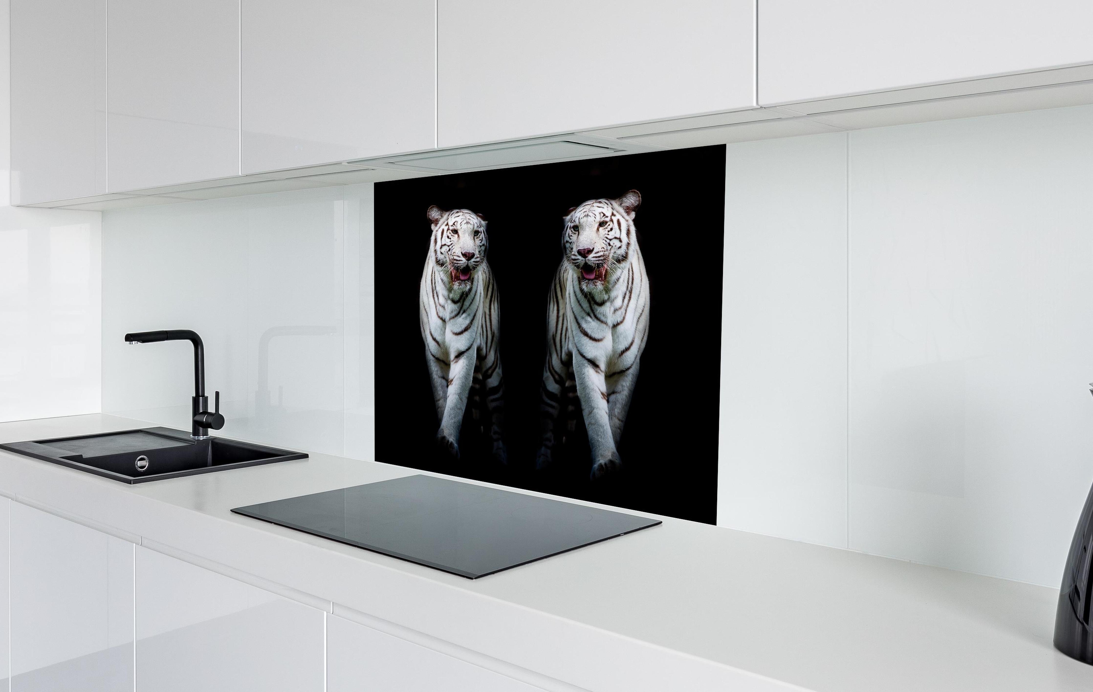 Spritzschutz - Zwei weiße Tiger auf schwarzem Hintergrund hinter einem Cerankochfeld zwischen Holz-Kochutensilien
