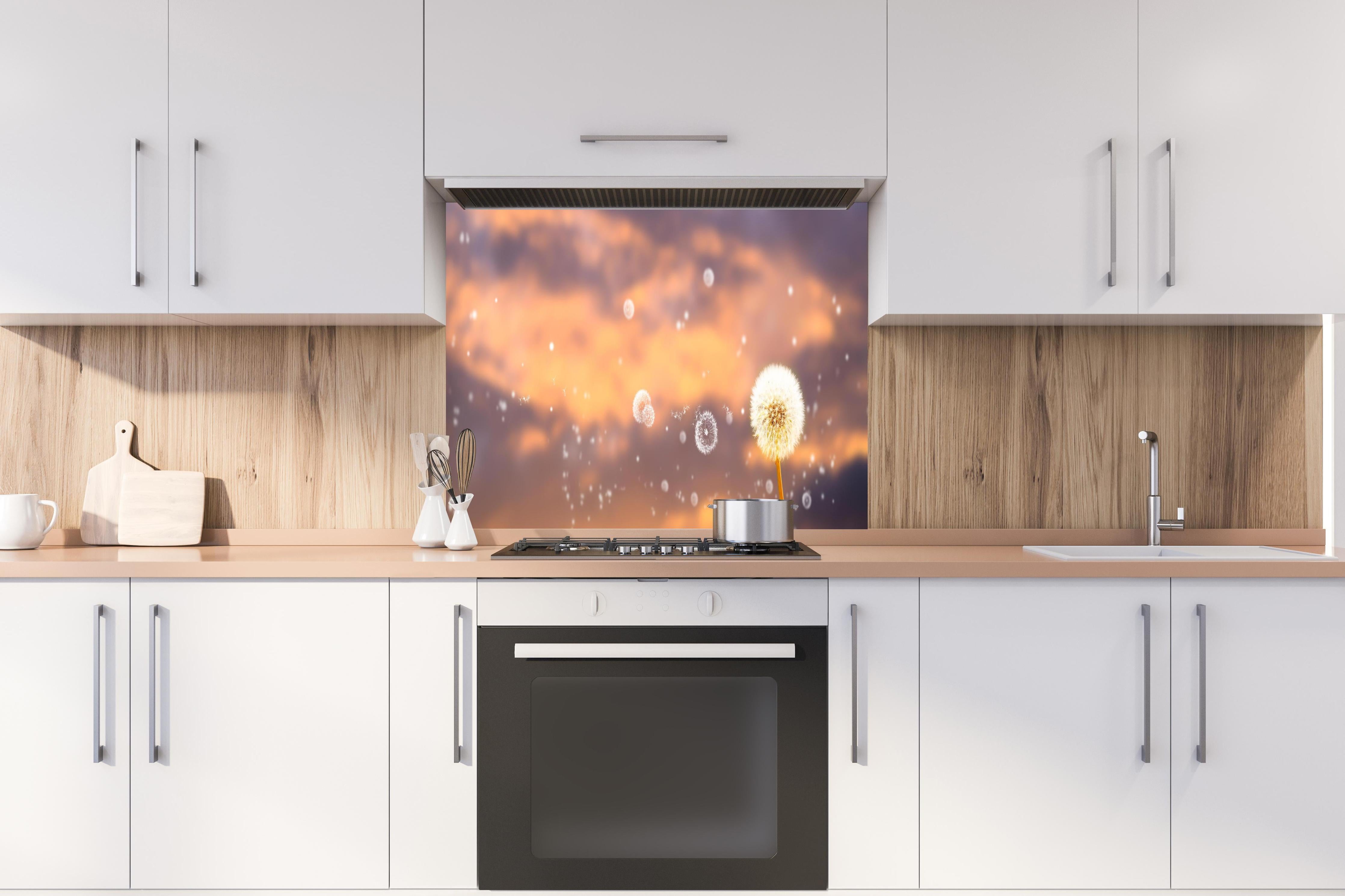 Spritzschutz - blütenstaub von pusteblumen in der abendsonne hinter einem Cerankochfeld zwischen Holz-Kochutensilien
