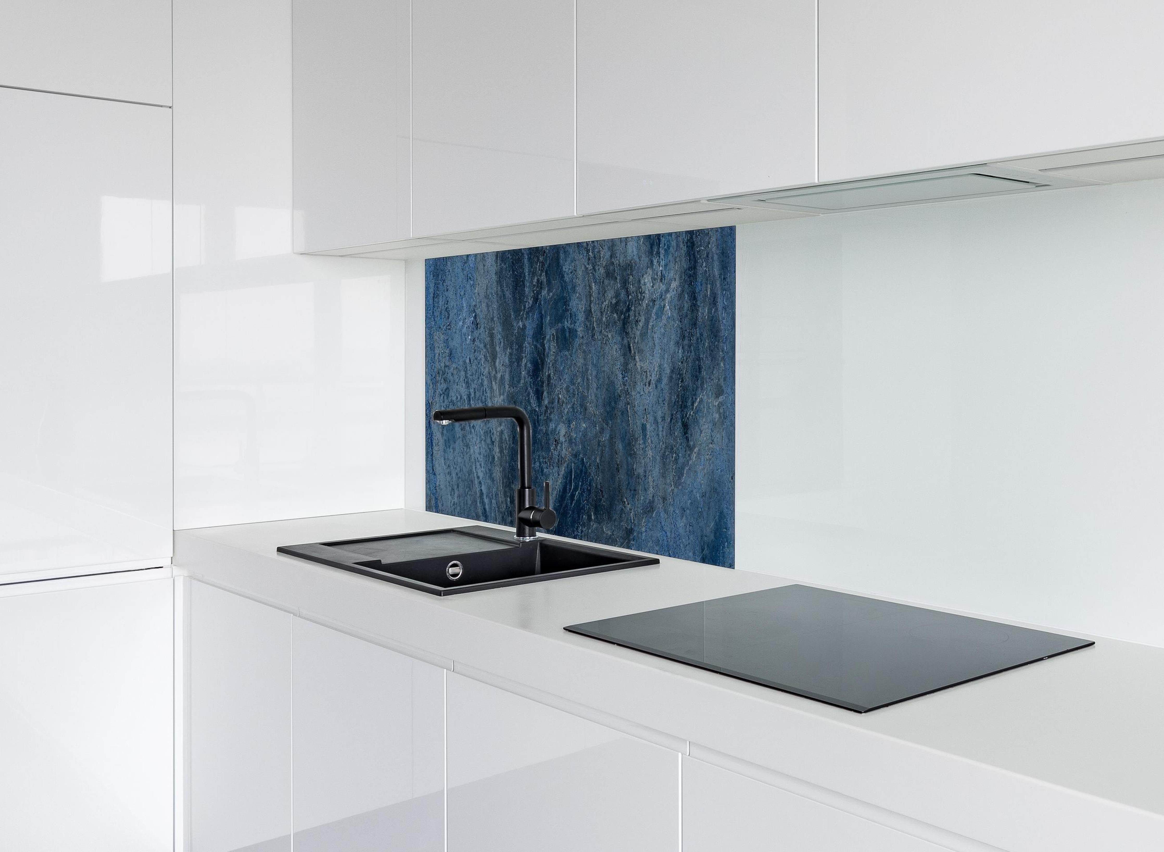 Spritzschutz - dunkelblaue Marmor Steinstruktur hinter einem Cerankochfeld zwischen Holz-Kochutensilien
