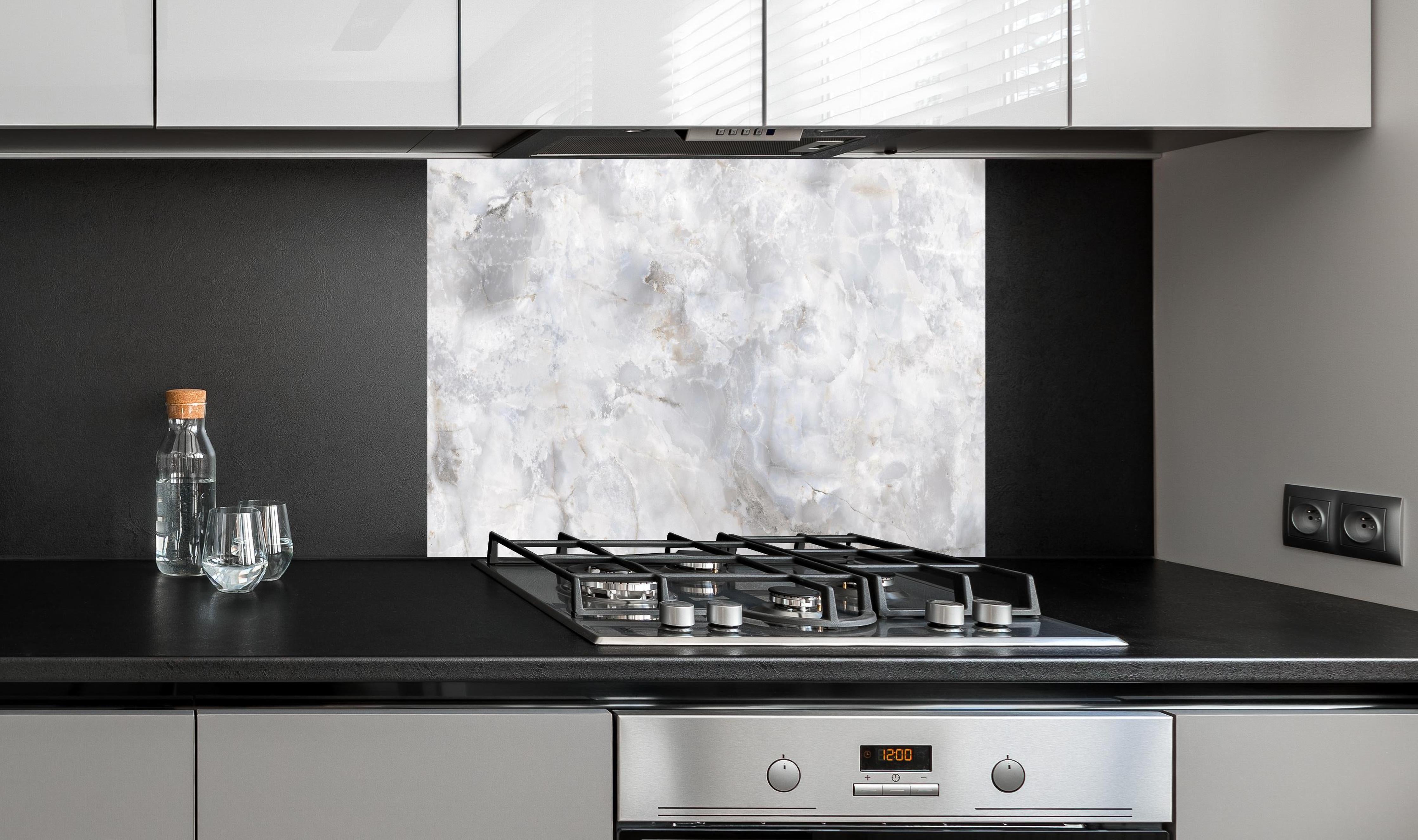 Spritzschutz - onyx marmor textur hinter einem Cerankochfeld zwischen Holz-Kochutensilien
