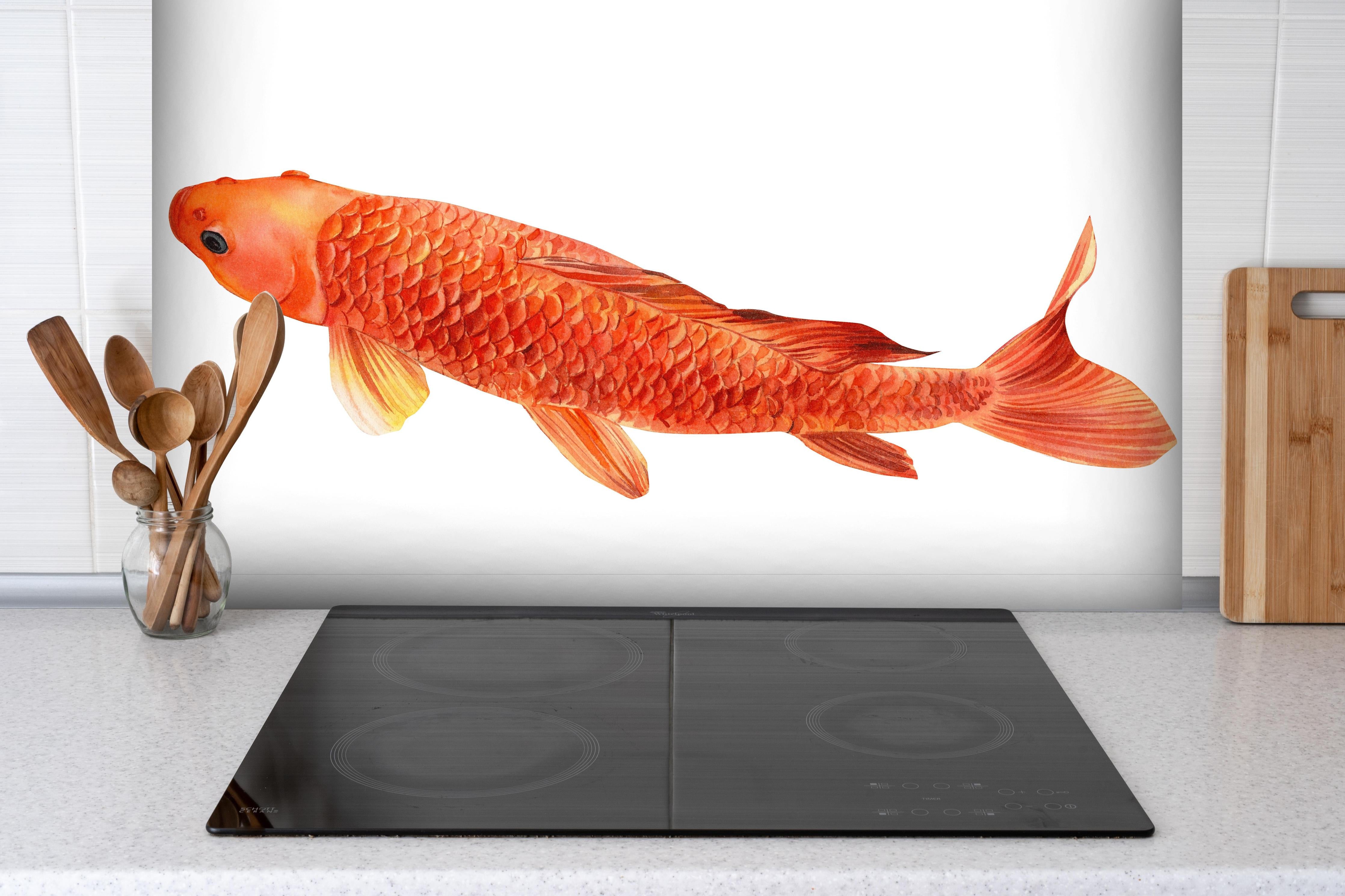 Spritzschutz - orangefarbener Koi hinter einem Cerankochfeld zwischen Holz-Kochutensilien

