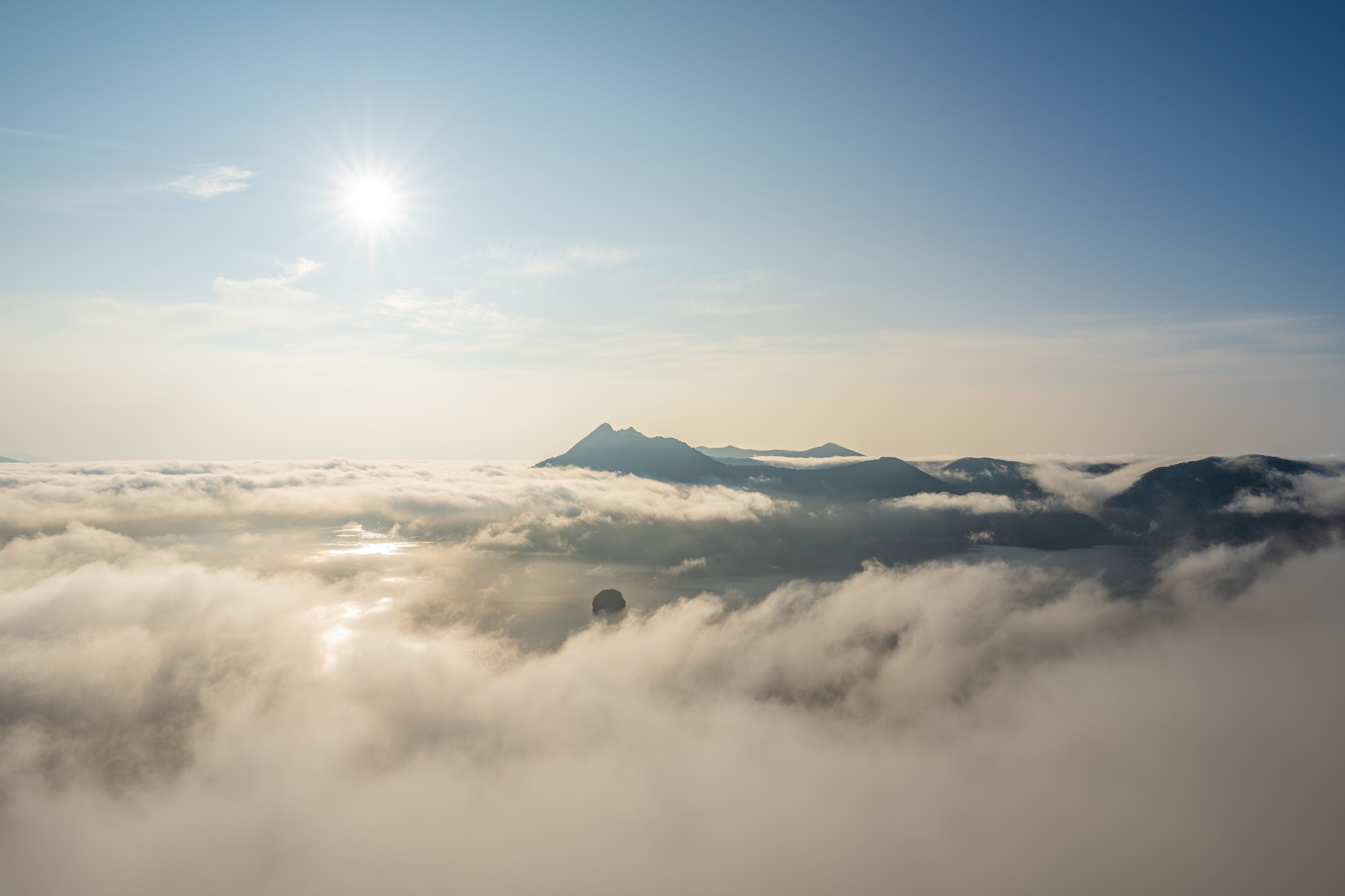 WC-Rückwand-Sonnenaufgang über nebelverhüllten Bergen