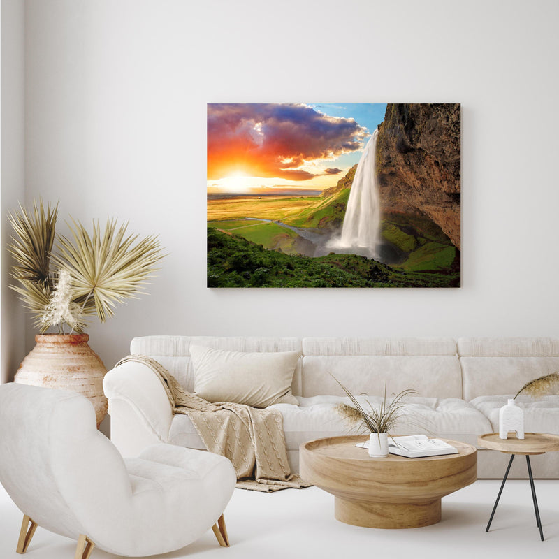 Wandbild -  Seljalandsfoss Wasserfall bei Sonnenuntergang in exotisch eingerichtetem Wohnzimmer über gemütlicher Couch