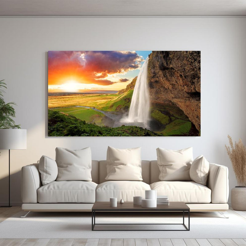 Wandbild -  Seljalandsfoss Wasserfall bei Sonnenuntergang hinter sanfter Couch mit cremefarbenen großen Kissen