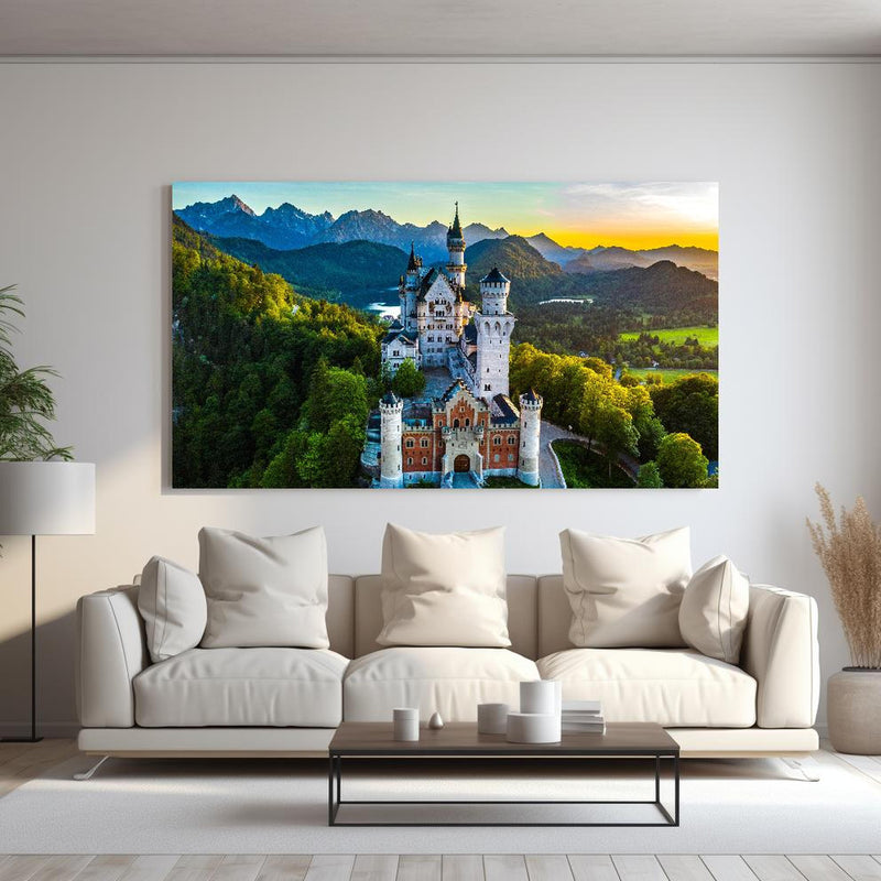 Wandbild -  glanzvolles Märchenschloss Neuschwanstein hinter sanfter Couch mit cremefarbenen großen Kissen