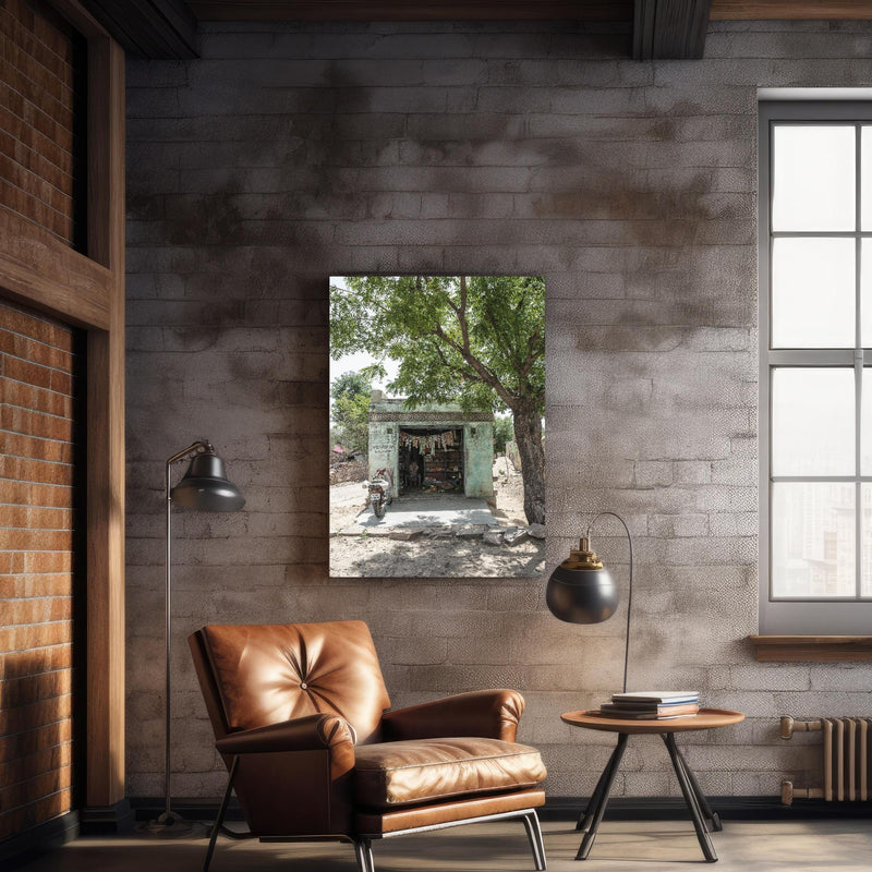 Wandbild - Alter Laden  über geschmackvollem Sessel an rustikaler Ziegelwand