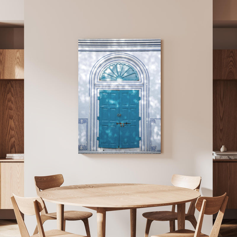 Wandbild - Blaue Tür - Architektur an beiger Wand hinter handgeschnitztem Holztisch 