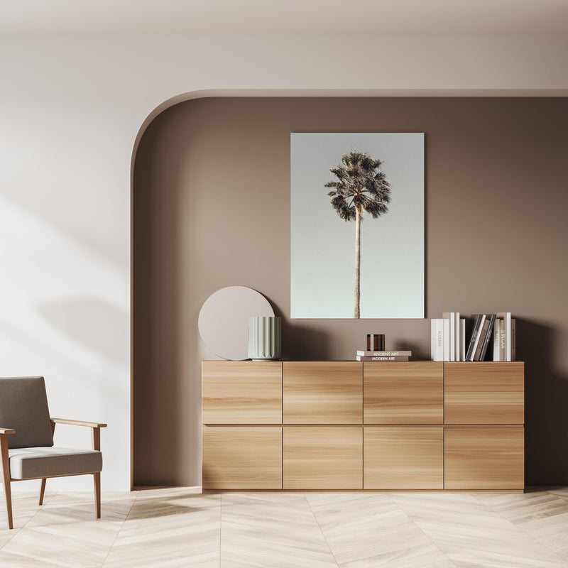 Wandbild - Einfache Palme  über doppelter Holzkommode mit Vase und Büchersammlung