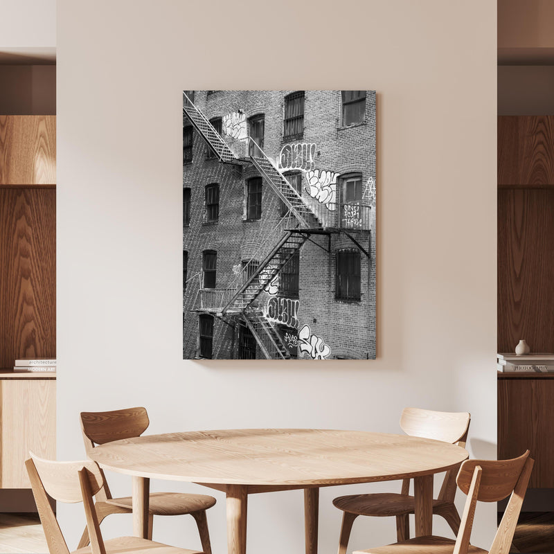 Wandbild - Feuerleiter in NYC- USA an beiger Wand hinter handgeschnitztem Holztisch 