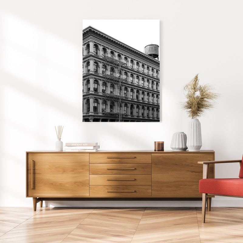 Wandbild - Gräuliches Foto - Architektur in NYC an cremefarbener Wand über klassischer Holzkommode